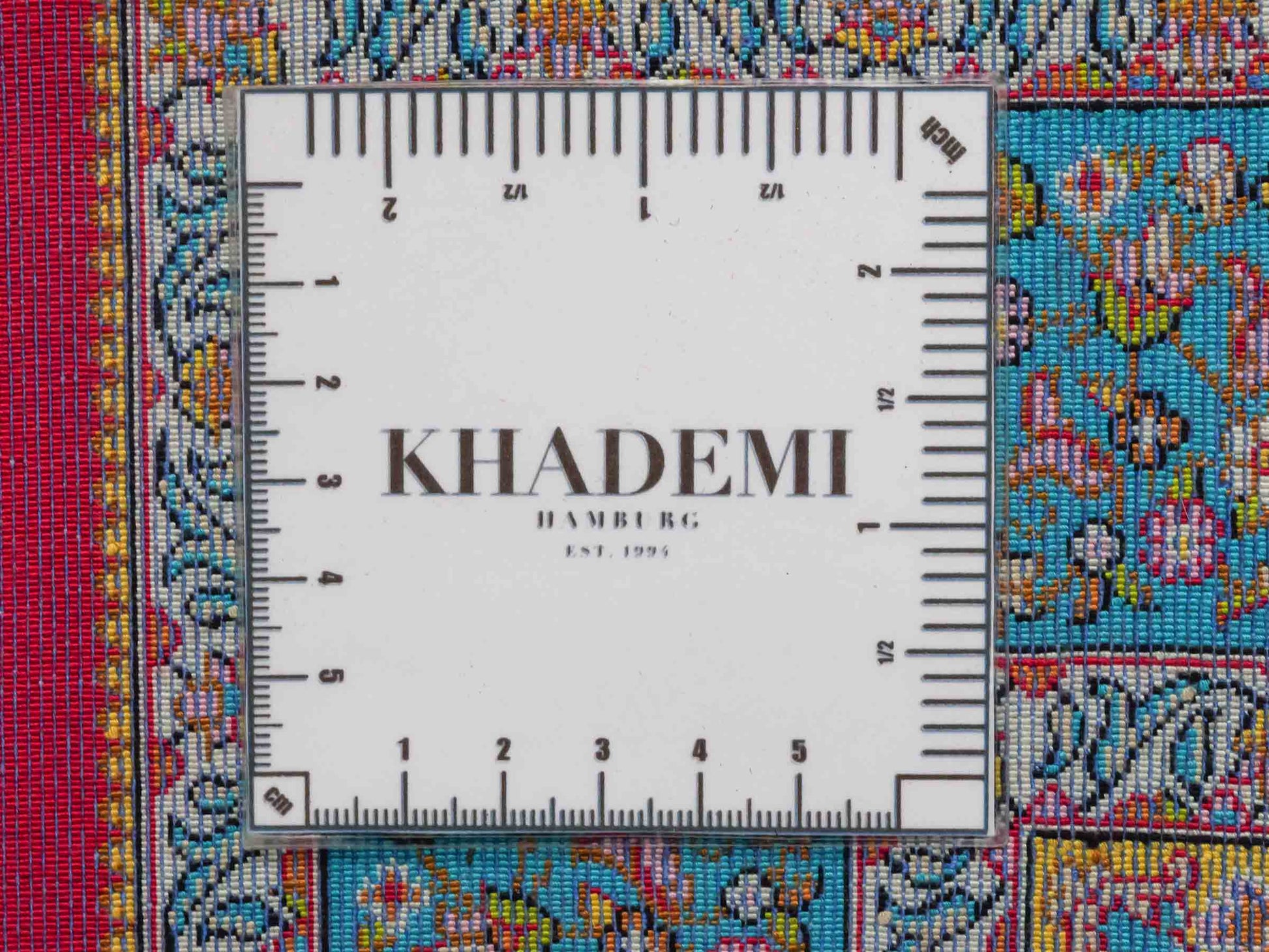 Ghom Maschinenteppich "Homay" 90 x 60 cm aus pflanzlicher Seide (Viskose) mit Medaillon, Rot, Hellblau. Teppichnummer: V45RD054H. Persian Luxury Collection by Khademi. Made in Iran / Persia – Vertrieb durch JUPITER Intl.