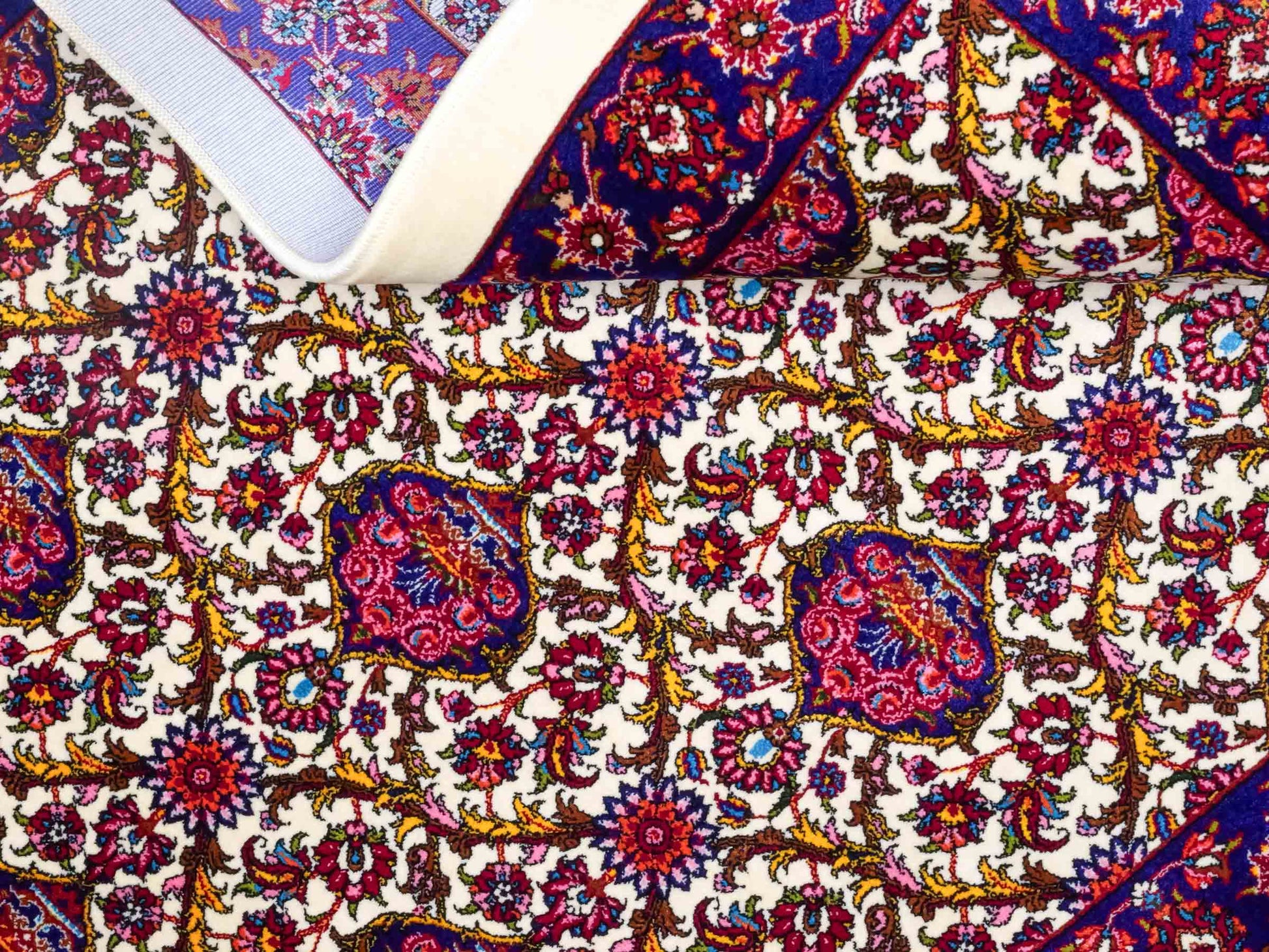 Ghom Maschinenteppich "Kiyumars" 90 x 60 cm aus pflanzlicher Seide (Viskose), Allover-Design, Cremeweiß, Blau, Rot. Teppichnummer: V53CR054M. Persian Luxury Collection by Khademi. Made in Iran / Persia – Vertrieb durch JUPITER Intl.