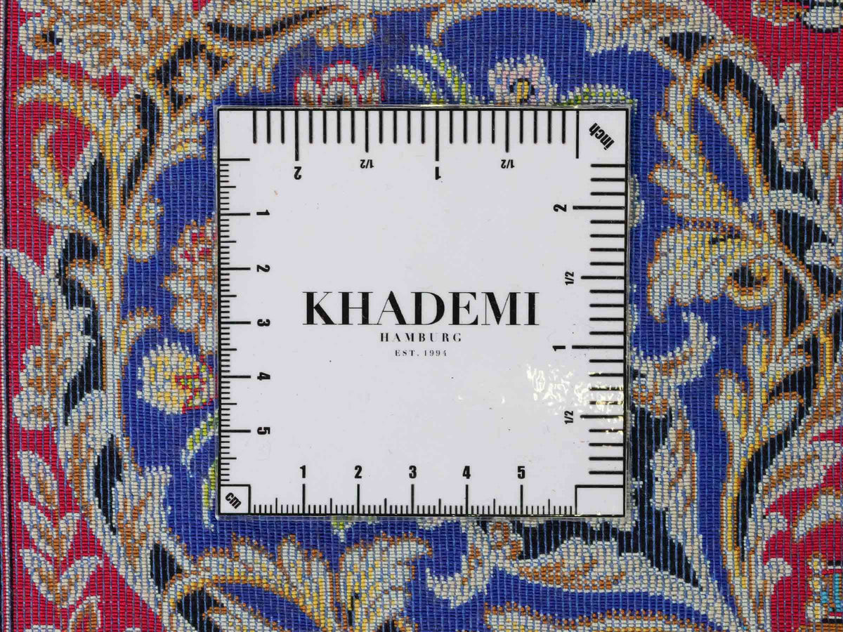 Ghom Maschinenteppich "Kubad" 225 x 150 cm, mit Medaillon, aus pflanzlicher Seide (Viskose), Dunkelblau/Rot. Teppichnummer: V70DB338H. Persian Luxury Collection by Khademi. Made in Iran / Persia – Vertrieb durch JUPITER Intl.