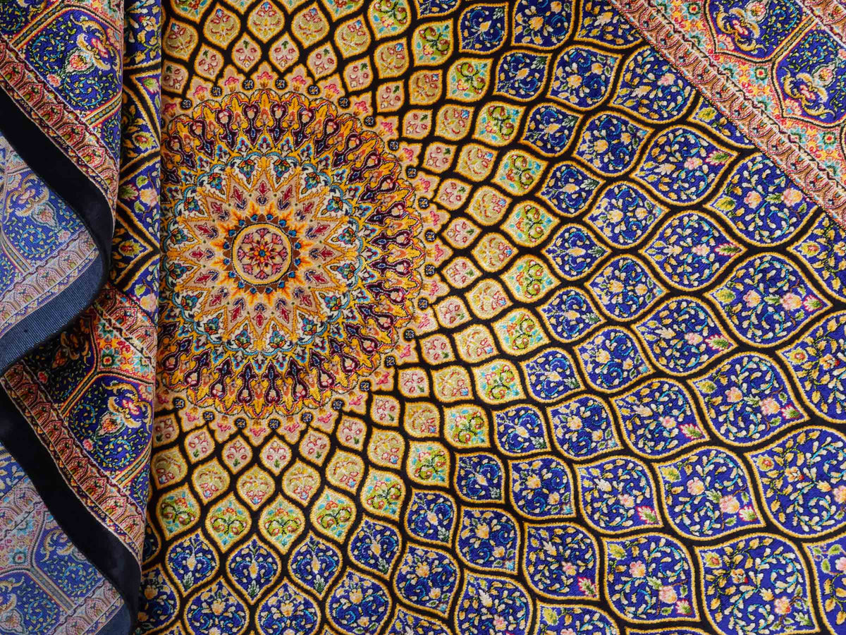 Ghom Maschinenteppich "Manuchehr" 150 x 100 cm, mit Medaillon, aus pflanzlicher Seide (Viskose), Schwarz/Blau/Gold. Teppichnummer: V56BD150H. Persian Luxury Collection by Khademi. Made in Iran / Persia – Vertrieb durch JUPITER Intl.