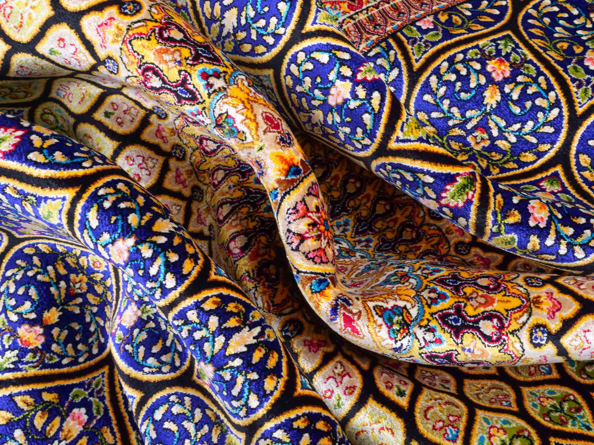 Ghom Maschinenteppich "Manuchehr" 150 x 100 cm, mit Medaillon, aus pflanzlicher Seide (Viskose), Schwarz/Blau/Gold. Teppichnummer: V56BD150H. Persian Luxury Collection by Khademi. Made in Iran / Persia – Vertrieb durch JUPITER Intl.