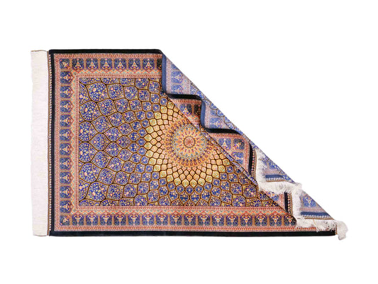 Ghom Maschinenteppich "Manuchehr" 150 x 100 cm, mit Medaillon, aus pflanzlicher Seide (Viskose), Schwarz/Blau/Gold. Teppichnummer: V56BD150H. Persian Luxury Collection by Khademi. Made in Iran / Persia – Vertrieb durch JUPITER Intl.