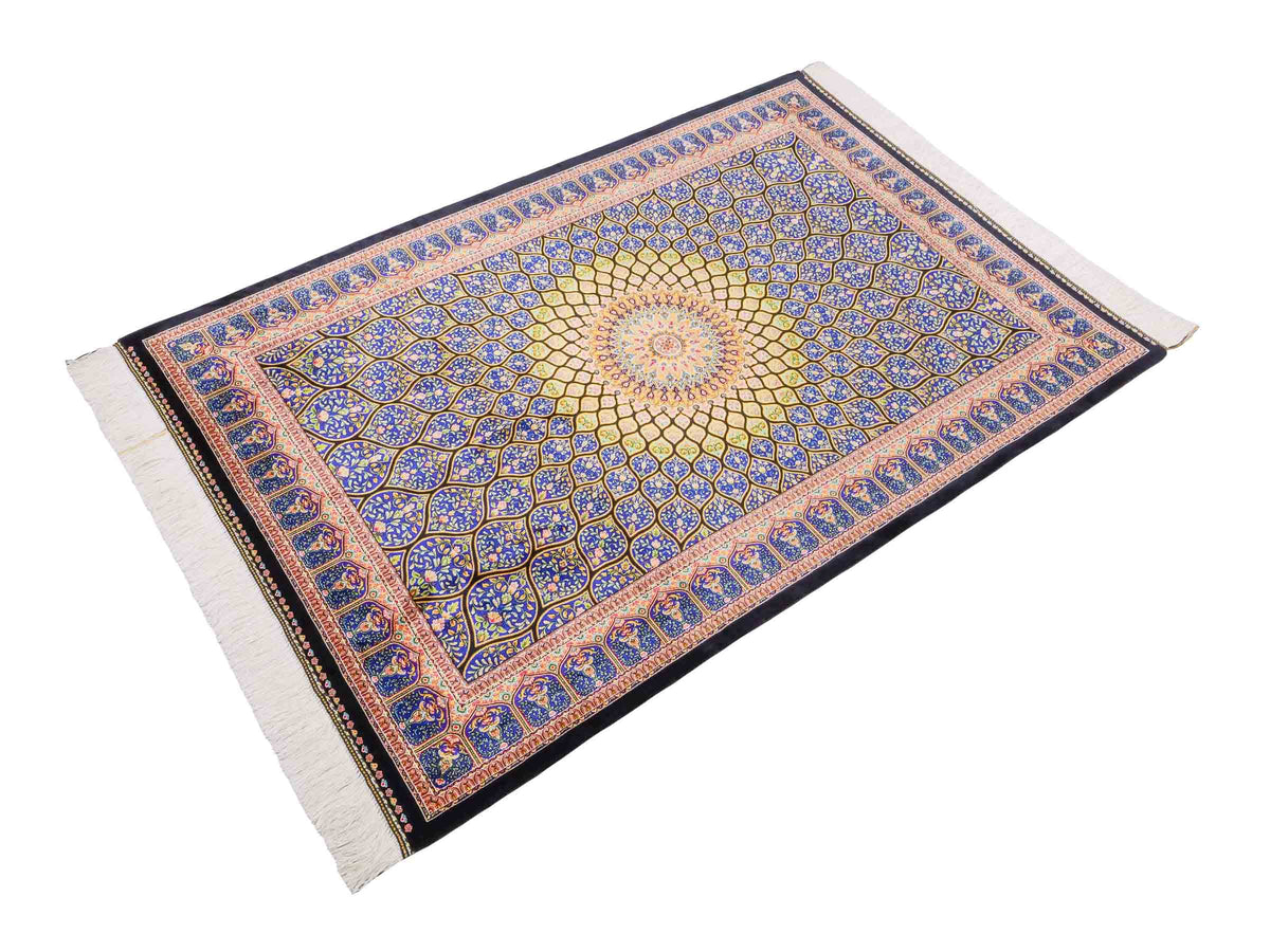 Ghom Maschinenteppich "Manuchehr" 150 x 100 cm, mit Medaillon, aus pflanzlicher Seide (Viskose), Schwarz/Blau/Gold. Teppichnummer: V56BD150H. Persian Luxury Collection by Khademi. Made in Iran / Persia – Vertrieb durch JUPITER Intl.