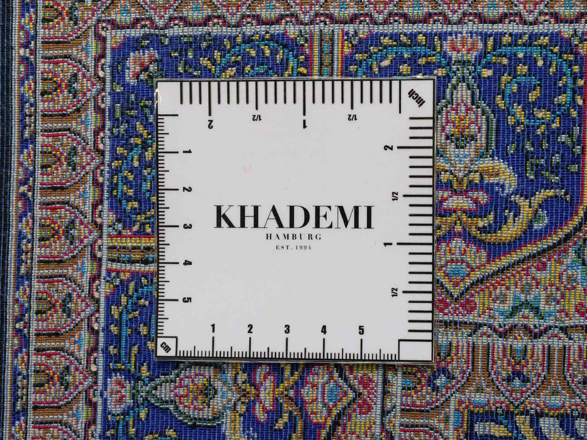 Ghom Maschinenteppich "Manuchehr" 150 x 100 cm, mit Medaillon, aus pflanzlicher Seide (Viskose), Schwarz/Blau/Gold. Teppichnummer: V56BD150H. Persian Luxury Collection by Khademi. Made in Iran / Persia – Vertrieb durch JUPITER Intl.