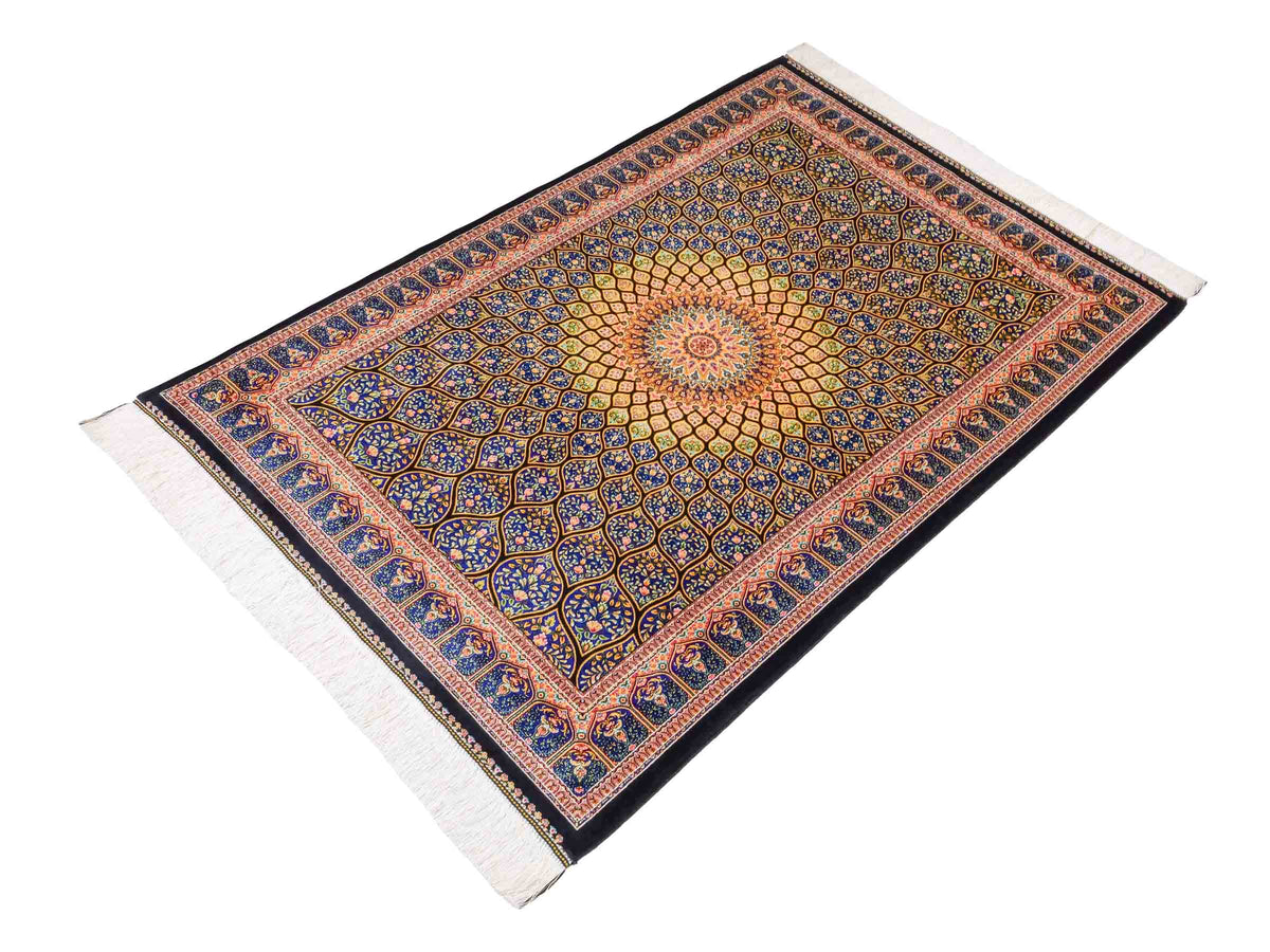 Ghom Maschinenteppich "Manuchehr" 150 x 100 cm, mit Medaillon, aus pflanzlicher Seide (Viskose), Schwarz/Blau/Gold. Teppichnummer: V56BD150H. Persian Luxury Collection by Khademi. Made in Iran / Persia – Vertrieb durch JUPITER Intl.