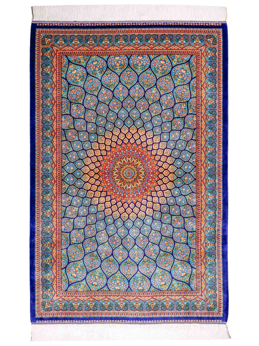 Ghom Maschinenteppich "Manuchehr" 150 x 100 cm, mit Medaillon, aus pflanzlicher Seide (Viskose), Dunkelblau/Blau. Teppichnummer: V56DB150H. Persian Luxury Collection by Khademi. Made in Iran / Persia – Vertrieb durch JUPITER Intl.