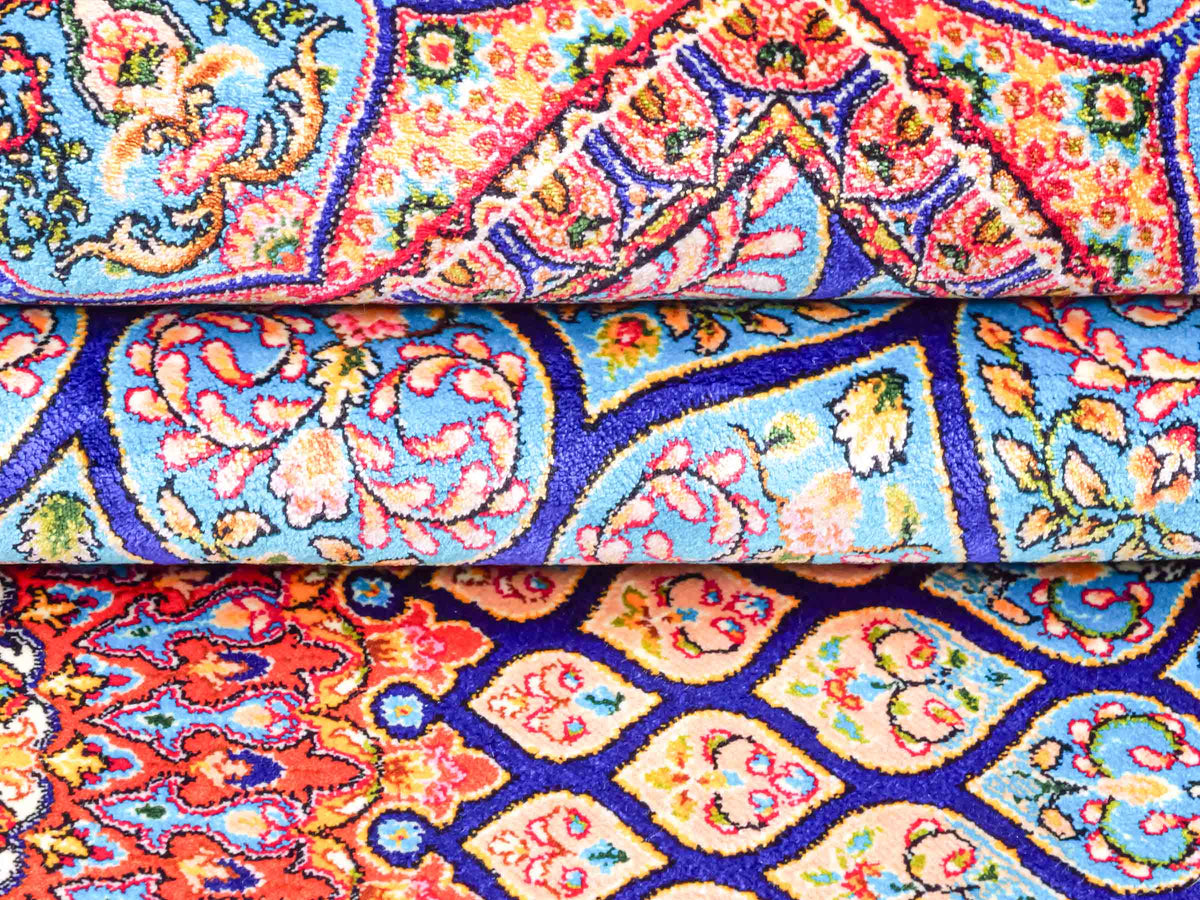 Ghom Maschinenteppich "Manuchehr" 150 x 100 cm, mit Medaillon, aus pflanzlicher Seide (Viskose), Dunkelblau/Blau. Teppichnummer: V56DB150H. Persian Luxury Collection by Khademi. Made in Iran / Persia – Vertrieb durch JUPITER Intl.