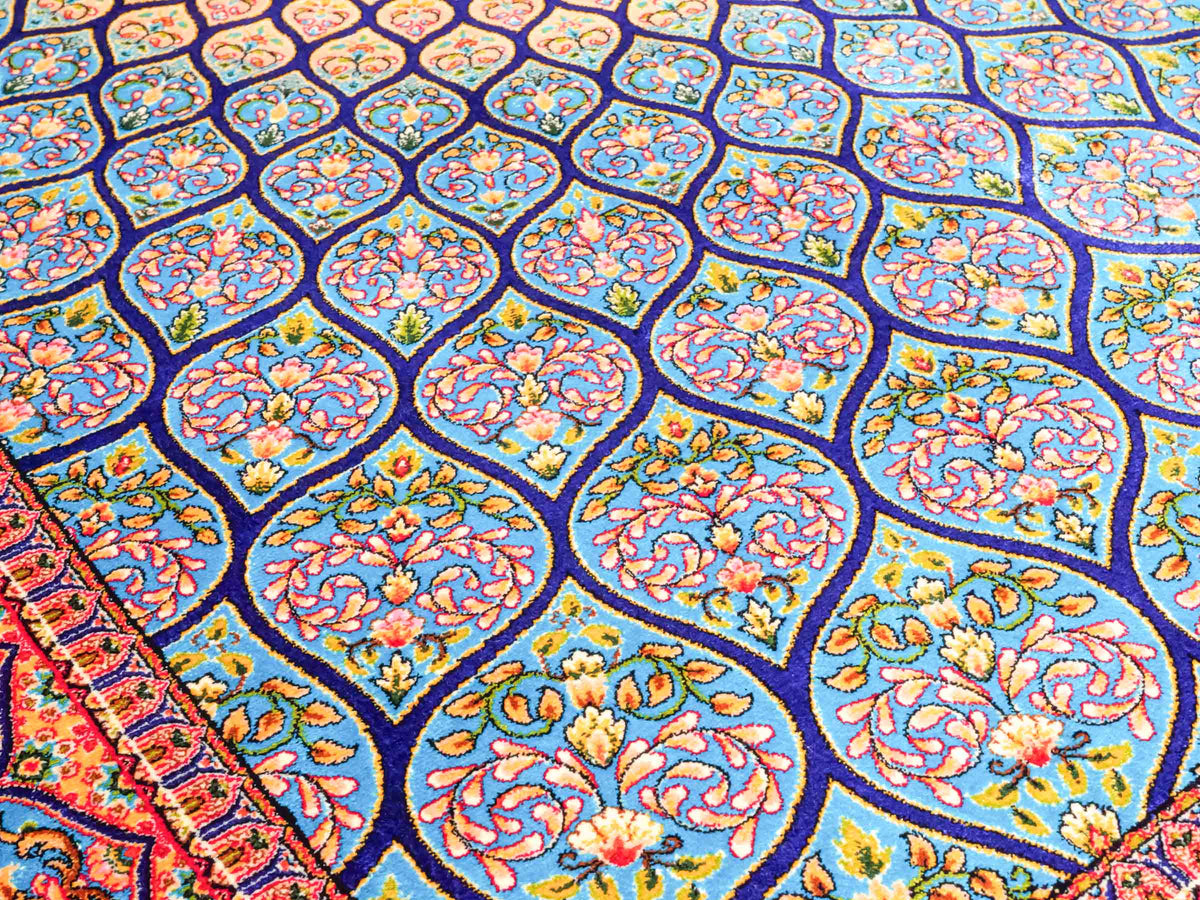 Ghom Maschinenteppich "Manuchehr" 150 x 100 cm, mit Medaillon, aus pflanzlicher Seide (Viskose), Dunkelblau/Blau. Teppichnummer: V56DB150H. Persian Luxury Collection by Khademi. Made in Iran / Persia – Vertrieb durch JUPITER Intl.