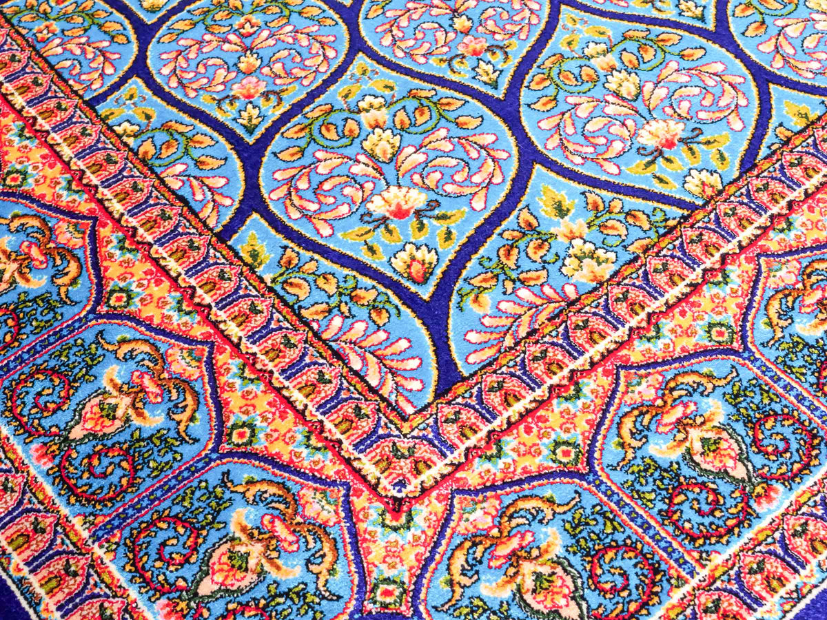 Ghom Maschinenteppich "Manuchehr" 150 x 100 cm, mit Medaillon, aus pflanzlicher Seide (Viskose), Dunkelblau/Blau. Teppichnummer: V56DB150H. Persian Luxury Collection by Khademi. Made in Iran / Persia – Vertrieb durch JUPITER Intl.