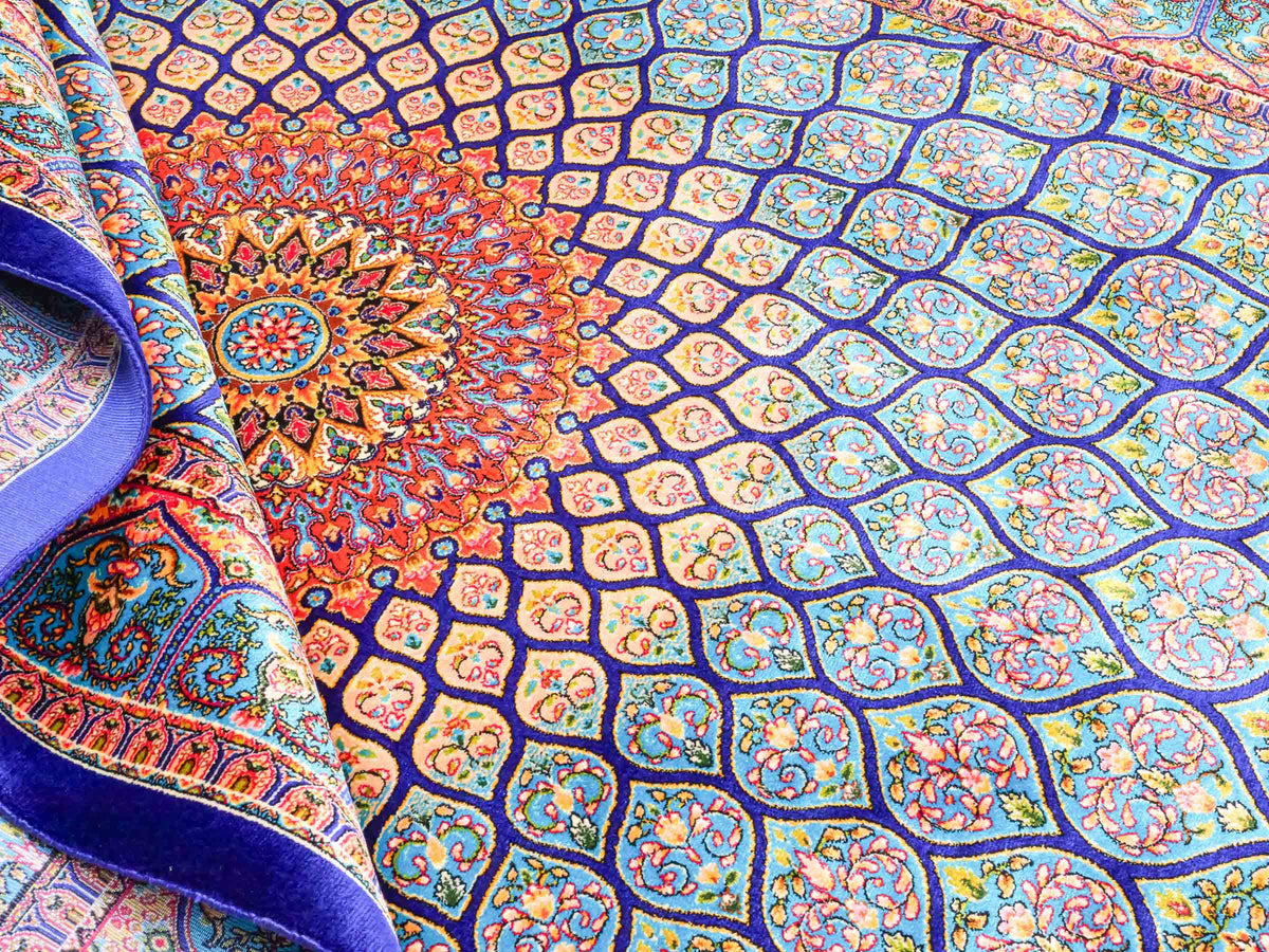 Ghom Maschinenteppich "Manuchehr" 150 x 100 cm, mit Medaillon, aus pflanzlicher Seide (Viskose), Dunkelblau/Blau. Teppichnummer: V56DB150H. Persian Luxury Collection by Khademi. Made in Iran / Persia – Vertrieb durch JUPITER Intl.