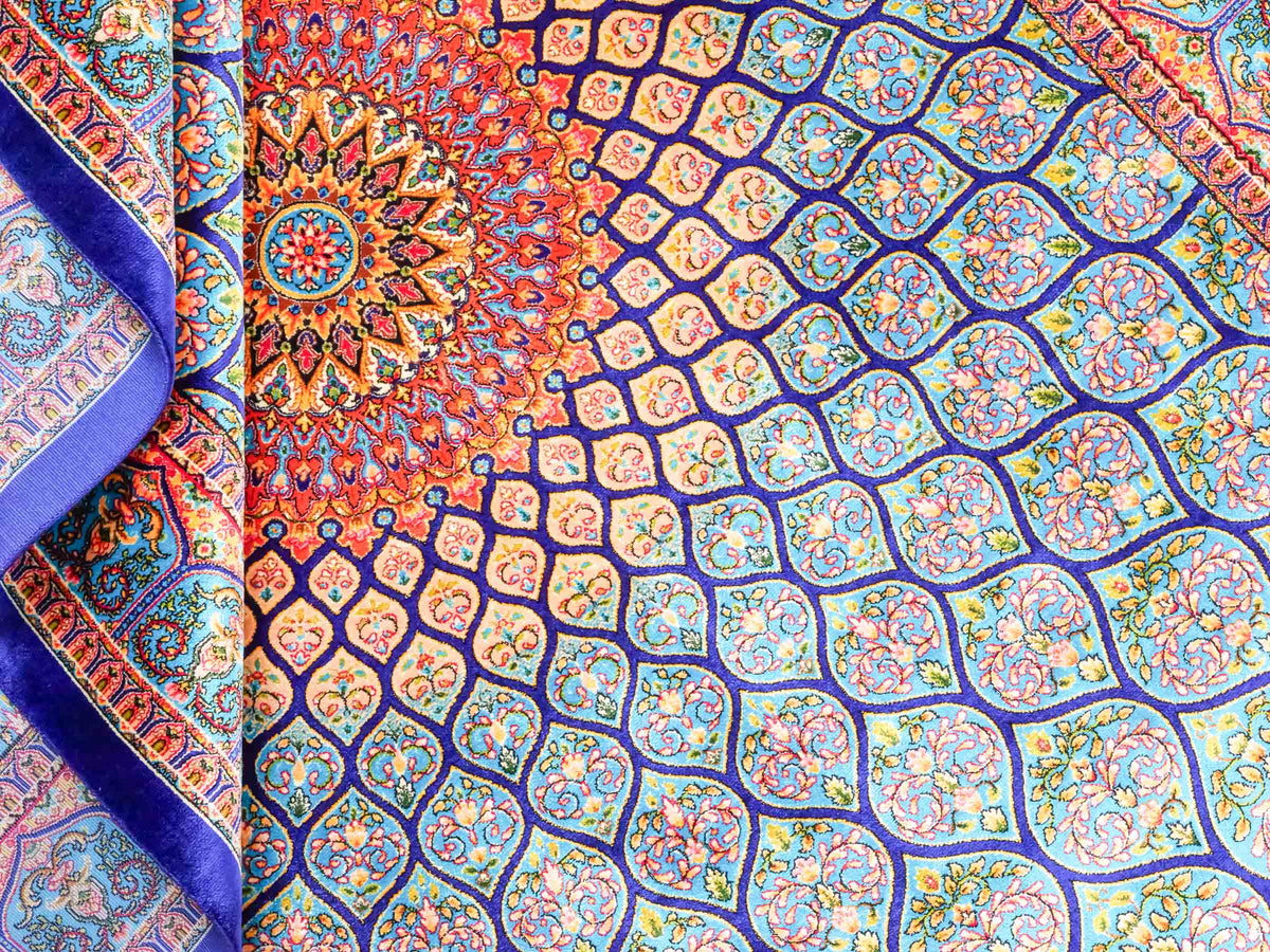 Ghom Maschinenteppich "Manuchehr" 150 x 100 cm, mit Medaillon, aus pflanzlicher Seide (Viskose), Dunkelblau/Blau. Teppichnummer: V56DB150H. Persian Luxury Collection by Khademi. Made in Iran / Persia – Vertrieb durch JUPITER Intl.