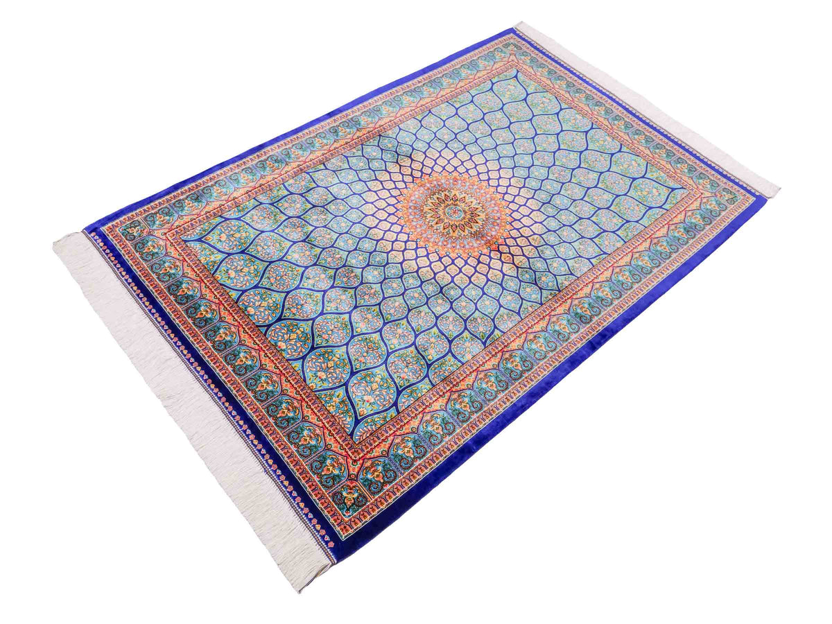 Ghom Maschinenteppich "Manuchehr" 150 x 100 cm, mit Medaillon, aus pflanzlicher Seide (Viskose), Dunkelblau/Blau. Teppichnummer: V56DB150H. Persian Luxury Collection by Khademi. Made in Iran / Persia – Vertrieb durch JUPITER Intl.