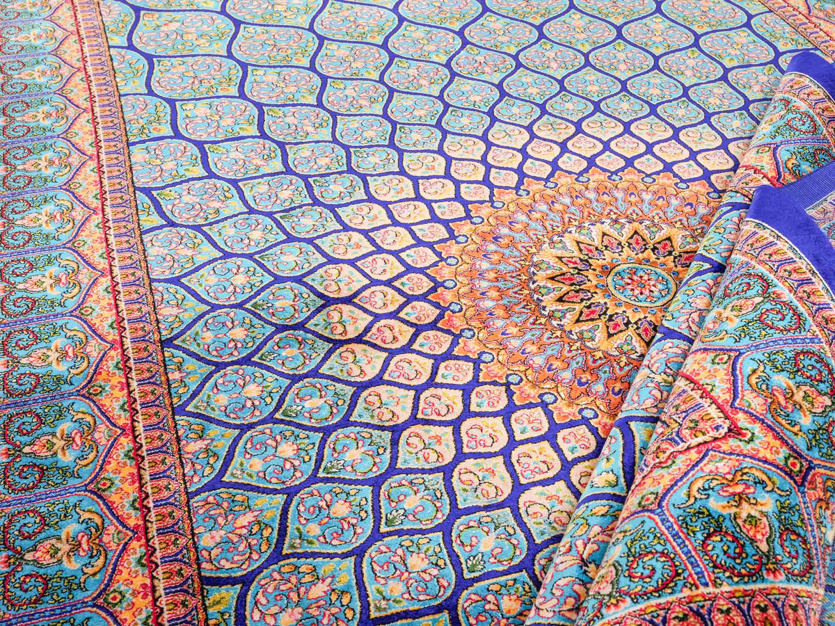 Ghom Maschinenteppich "Manuchehr" 150 x 100 cm, mit Medaillon, aus pflanzlicher Seide (Viskose), Dunkelblau/Blau. Teppichnummer: V56DB150H. Persian Luxury Collection by Khademi. Made in Iran / Persia – Vertrieb durch JUPITER Intl.
