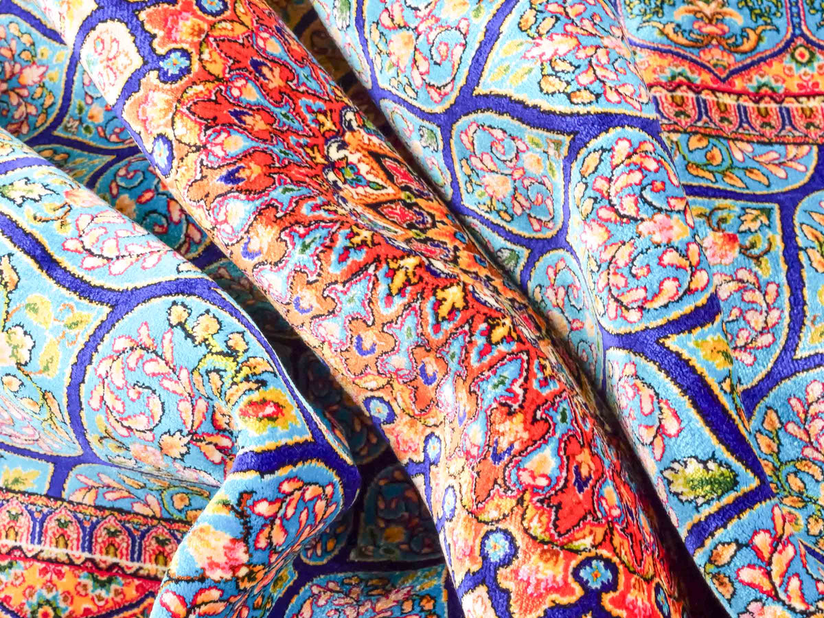Ghom Maschinenteppich "Manuchehr" 150 x 100 cm, mit Medaillon, aus pflanzlicher Seide (Viskose), Dunkelblau/Blau. Teppichnummer: V56DB150H. Persian Luxury Collection by Khademi. Made in Iran / Persia – Vertrieb durch JUPITER Intl.