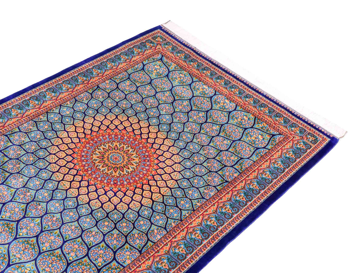 Ghom Maschinenteppich "Manuchehr" 150 x 100 cm, mit Medaillon, aus pflanzlicher Seide (Viskose), Dunkelblau/Blau. Teppichnummer: V56DB150H. Persian Luxury Collection by Khademi. Made in Iran / Persia – Vertrieb durch JUPITER Intl.