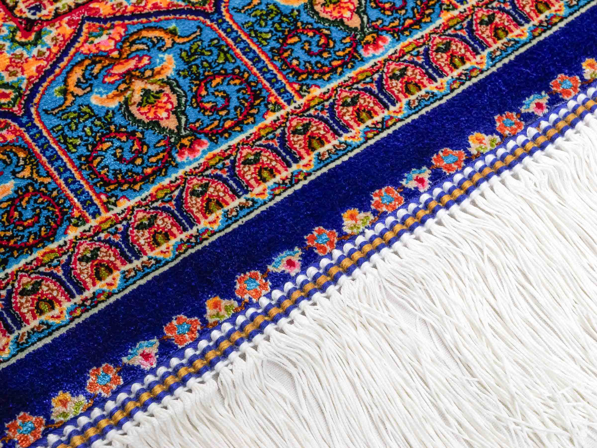 Ghom Maschinenteppich "Manuchehr" 150 x 100 cm, mit Medaillon, aus pflanzlicher Seide (Viskose), Dunkelblau/Blau. Teppichnummer: V56DB150H. Persian Luxury Collection by Khademi. Made in Iran / Persia – Vertrieb durch JUPITER Intl.