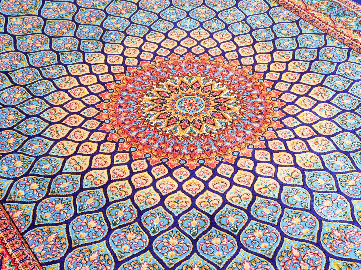 Ghom Maschinenteppich "Manuchehr" 150 x 100 cm, mit Medaillon, aus pflanzlicher Seide (Viskose), Dunkelblau/Blau. Teppichnummer: V56DB150H. Persian Luxury Collection by Khademi. Made in Iran / Persia – Vertrieb durch JUPITER Intl.