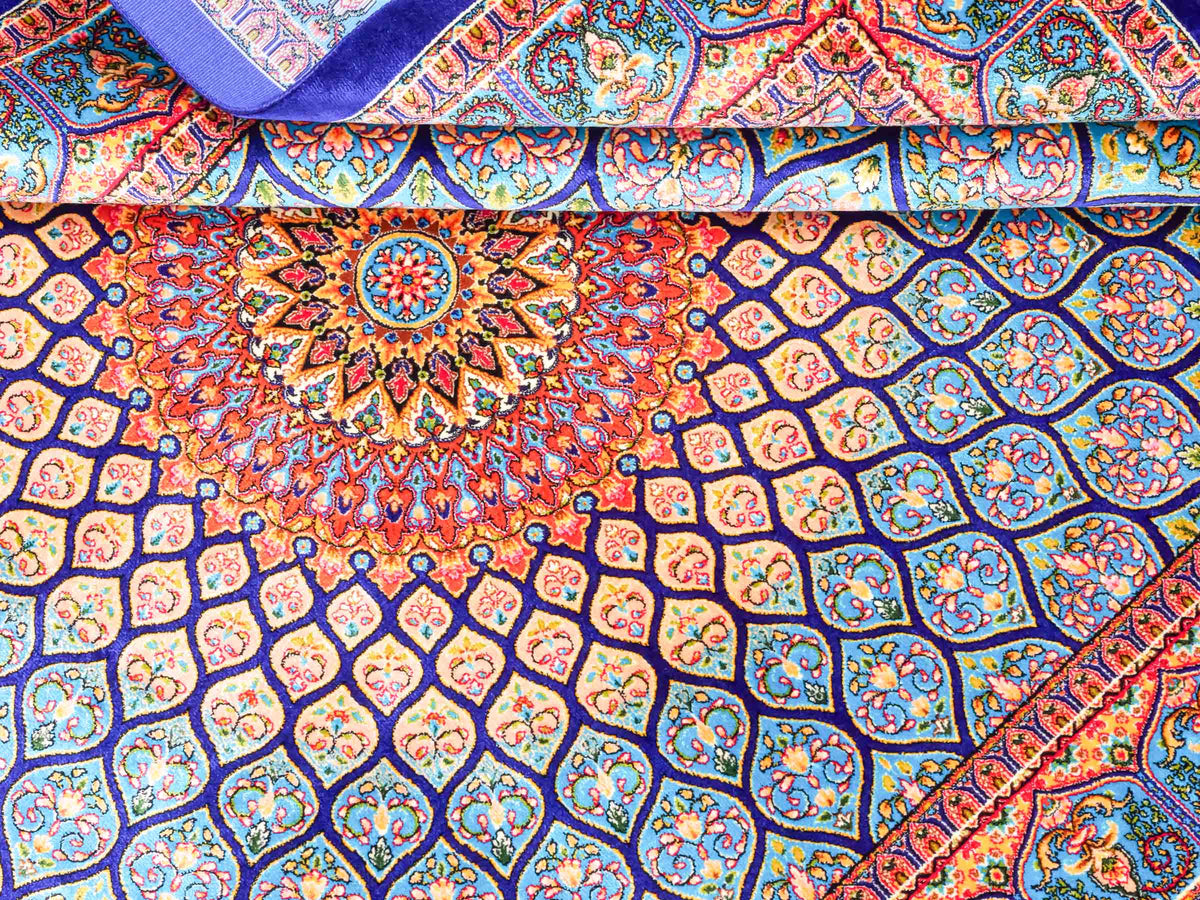 Ghom Maschinenteppich "Manuchehr" 150 x 100 cm, mit Medaillon, aus pflanzlicher Seide (Viskose), Dunkelblau/Blau. Teppichnummer: V56DB150H. Persian Luxury Collection by Khademi. Made in Iran / Persia – Vertrieb durch JUPITER Intl.