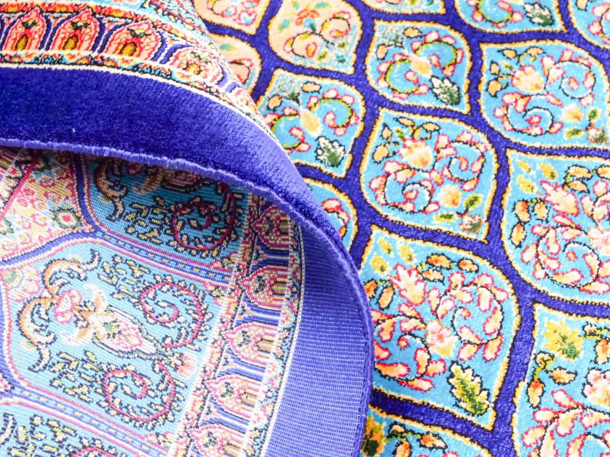 Ghom Maschinenteppich "Manuchehr" 150 x 100 cm, mit Medaillon, aus pflanzlicher Seide (Viskose), Dunkelblau/Blau. Teppichnummer: V56DB150H. Persian Luxury Collection by Khademi. Made in Iran / Persia – Vertrieb durch JUPITER Intl.
