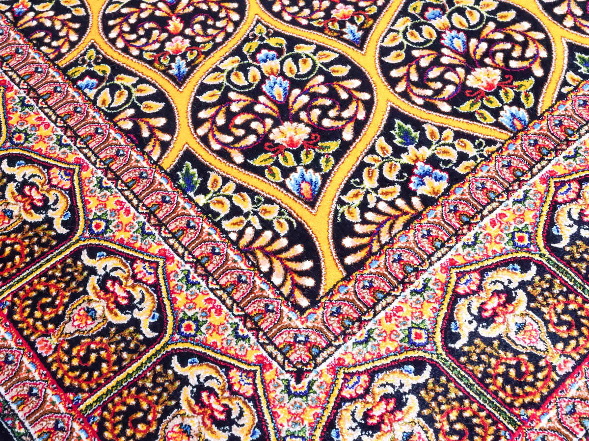 Ghom Maschinenteppich "Manuchehr" 150 x 100 cm, mit Medaillon, aus pflanzlicher Seide (Viskose), Schwarz/Gold. Teppichnummer: V56BG150H. Persian Luxury Collection by Khademi. Made in Iran / Persia – Vertrieb durch JUPITER Intl.