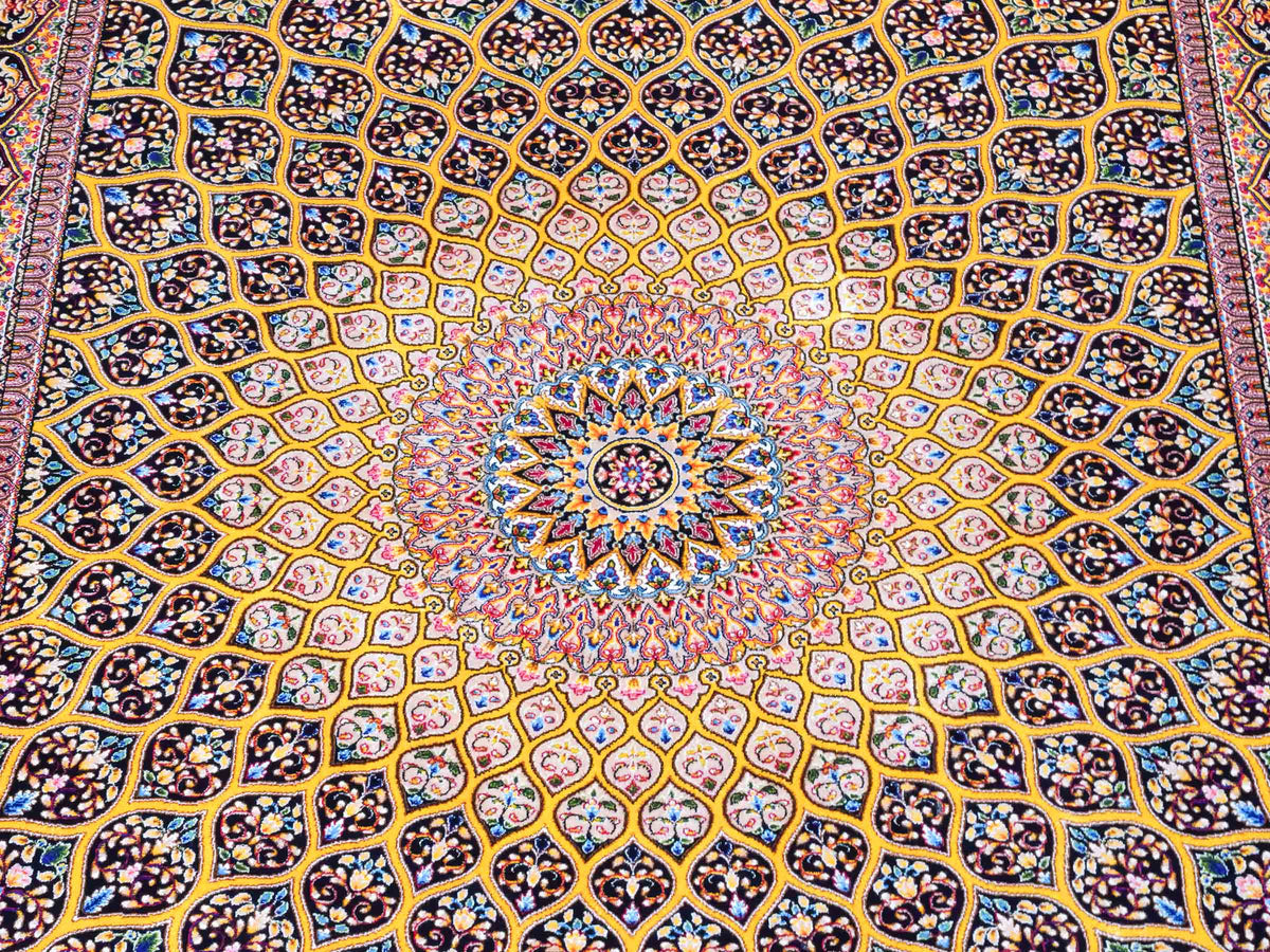 Ghom Maschinenteppich "Manuchehr" 150 x 100 cm, mit Medaillon, aus pflanzlicher Seide (Viskose), Schwarz/Gold. Teppichnummer: V56BG150H. Persian Luxury Collection by Khademi. Made in Iran / Persia – Vertrieb durch JUPITER Intl.