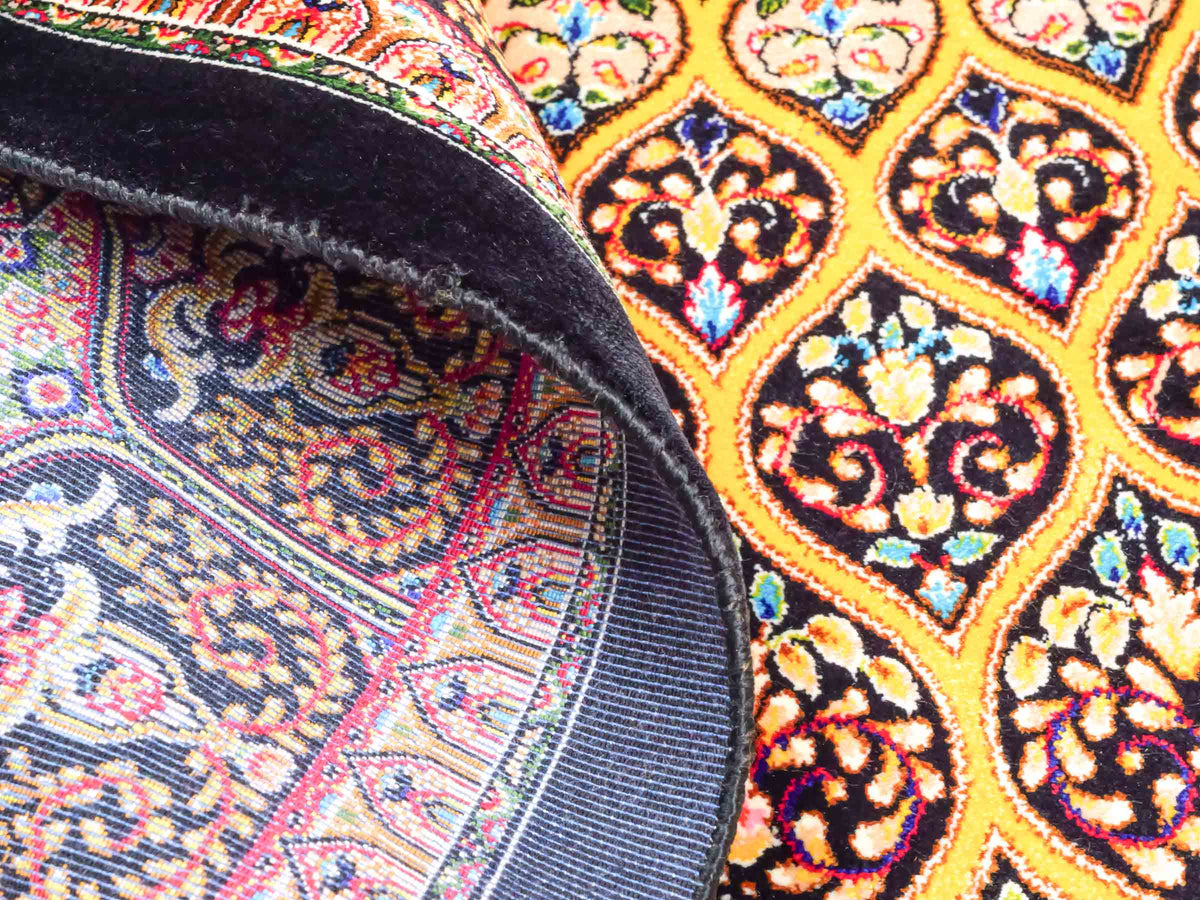 Ghom Maschinenteppich "Manuchehr" 150 x 100 cm, mit Medaillon, aus pflanzlicher Seide (Viskose), Schwarz/Gold. Teppichnummer: V56BG150H. Persian Luxury Collection by Khademi. Made in Iran / Persia – Vertrieb durch JUPITER Intl.