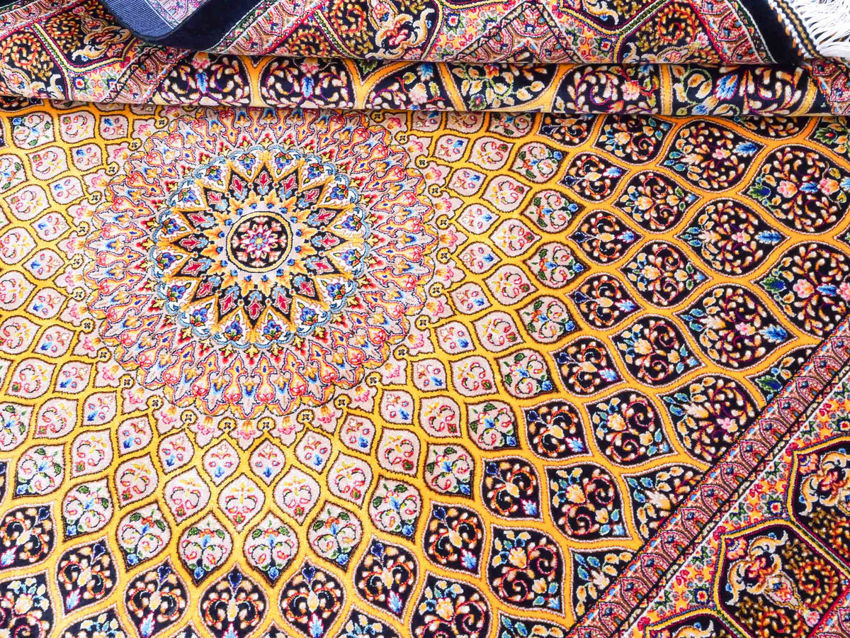Ghom Maschinenteppich "Manuchehr" 150 x 100 cm, mit Medaillon, aus pflanzlicher Seide (Viskose), Schwarz/Gold. Teppichnummer: V56BG150H. Persian Luxury Collection by Khademi. Made in Iran / Persia – Vertrieb durch JUPITER Intl.
