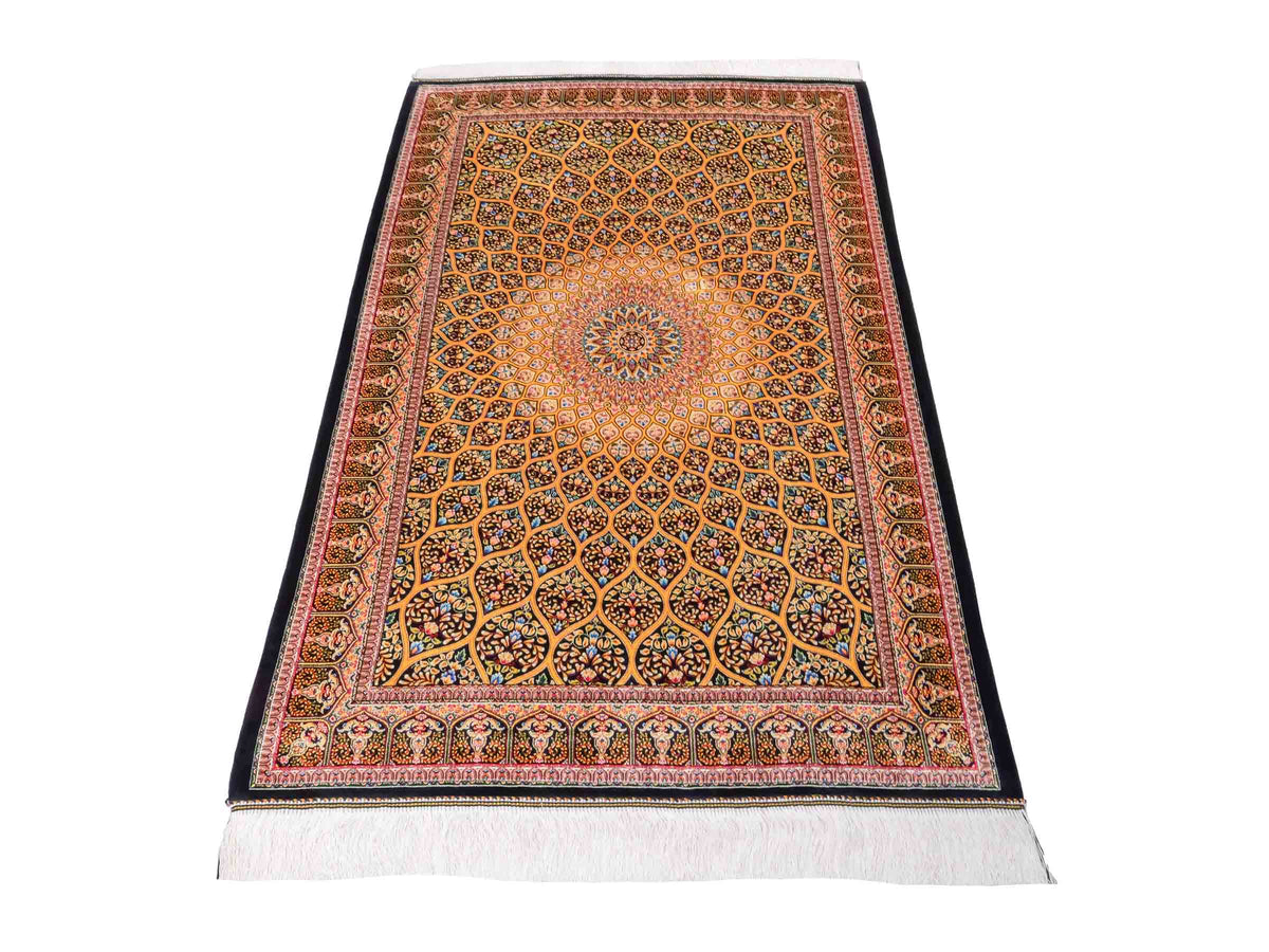 Ghom Maschinenteppich "Manuchehr" 150 x 100 cm, mit Medaillon, aus pflanzlicher Seide (Viskose), Schwarz/Gold. Teppichnummer: V56BG150H. Persian Luxury Collection by Khademi. Made in Iran / Persia – Vertrieb durch JUPITER Intl.