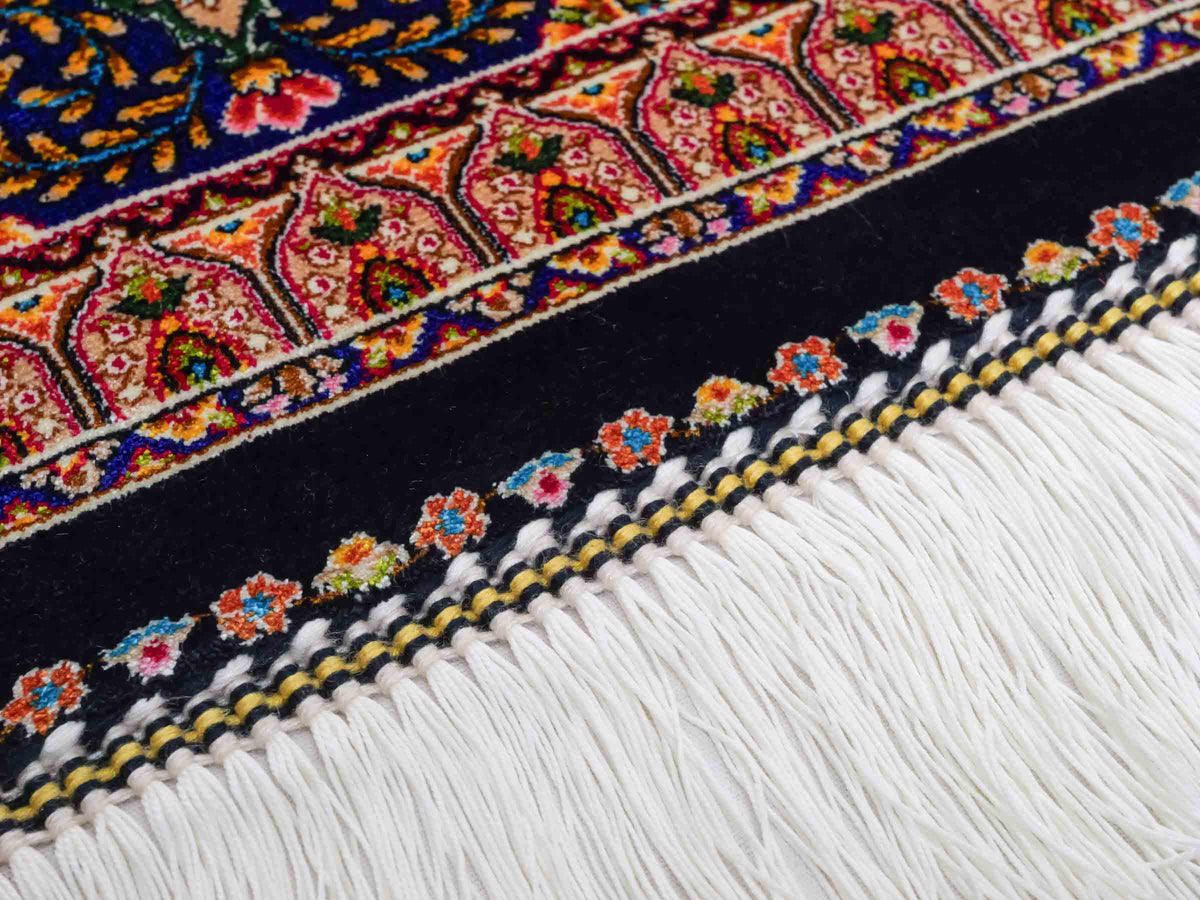 Ghom Maschinenteppich "Manuchehr" 225 x 150 cm, mit Medaillon, aus pflanzlicher Seide (Viskose), Schwarz/Blau/Gold. Teppichnummer: V56BD338H. Persian Luxury Collection by Khademi. Made in Iran / Persia – Vertrieb durch JUPITER Intl.