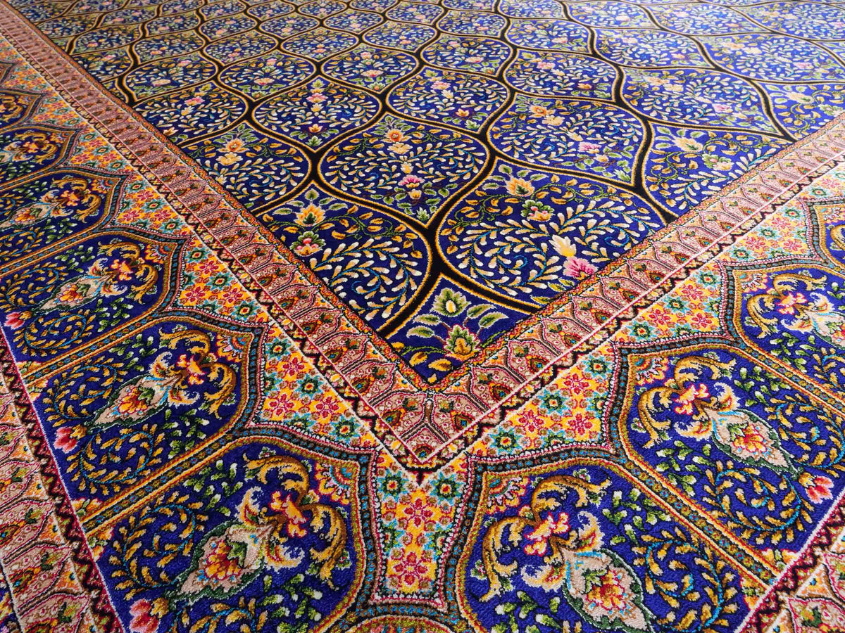 Ghom Maschinenteppich "Manuchehr" 225 x 150 cm, mit Medaillon, aus pflanzlicher Seide (Viskose), Schwarz/Blau/Gold. Teppichnummer: V56BD338H. Persian Luxury Collection by Khademi. Made in Iran / Persia – Vertrieb durch JUPITER Intl.
