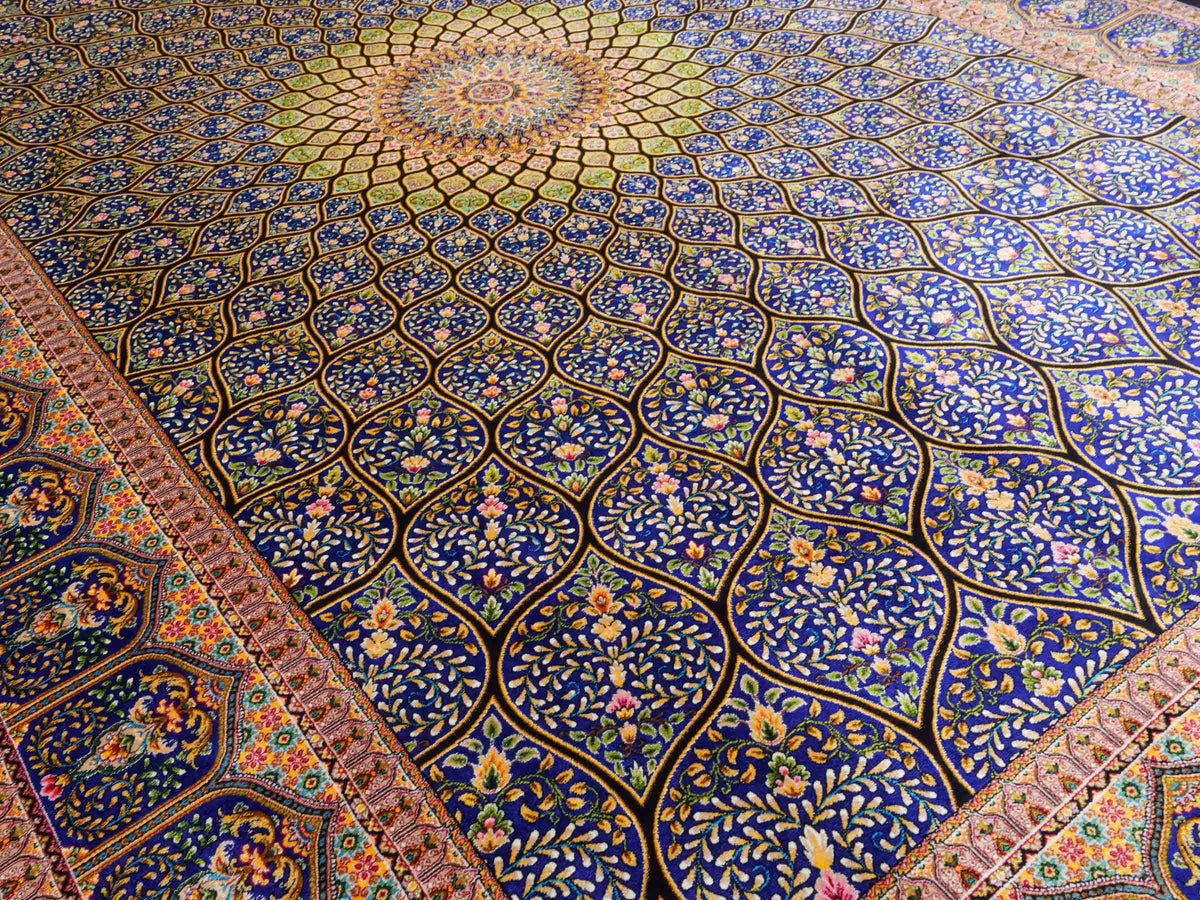 Ghom Maschinenteppich "Manuchehr" 225 x 150 cm, mit Medaillon, aus pflanzlicher Seide (Viskose), Schwarz/Blau/Gold. Teppichnummer: V56BD338H. Persian Luxury Collection by Khademi. Made in Iran / Persia – Vertrieb durch JUPITER Intl.