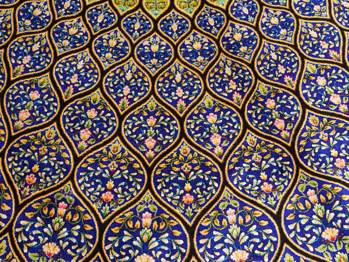 Ghom Maschinenteppich "Manuchehr" 225 x 150 cm, mit Medaillon, aus pflanzlicher Seide (Viskose), Schwarz/Blau/Gold. Teppichnummer: V56BD338H. Persian Luxury Collection by Khademi. Made in Iran / Persia – Vertrieb durch JUPITER Intl.