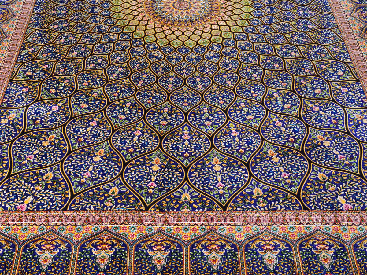 Ghom Maschinenteppich "Manuchehr" 225 x 150 cm, mit Medaillon, aus pflanzlicher Seide (Viskose), Schwarz/Blau/Gold. Teppichnummer: V56BD338H. Persian Luxury Collection by Khademi. Made in Iran / Persia – Vertrieb durch JUPITER Intl.