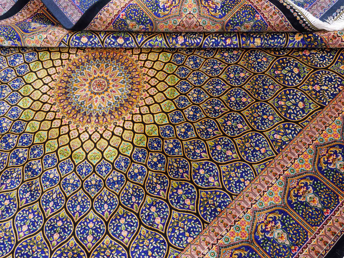 Ghom Maschinenteppich "Manuchehr" 225 x 150 cm, mit Medaillon, aus pflanzlicher Seide (Viskose), Schwarz/Blau/Gold. Teppichnummer: V56BD338H. Persian Luxury Collection by Khademi. Made in Iran / Persia – Vertrieb durch JUPITER Intl.