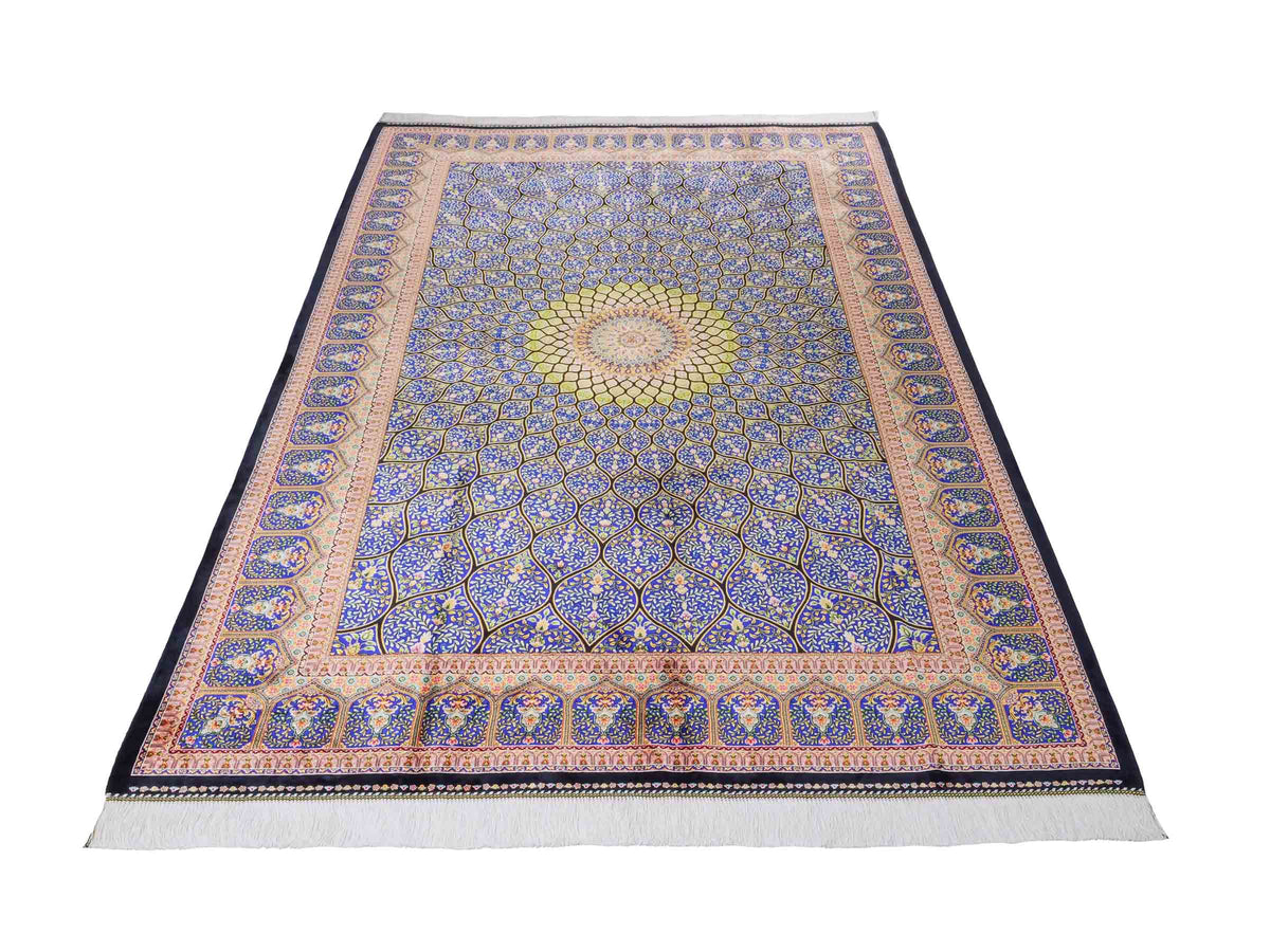 Ghom Maschinenteppich "Manuchehr" 225 x 150 cm, mit Medaillon, aus pflanzlicher Seide (Viskose), Schwarz/Blau/Gold. Teppichnummer: V56BD338H. Persian Luxury Collection by Khademi. Made in Iran / Persia – Vertrieb durch JUPITER Intl.