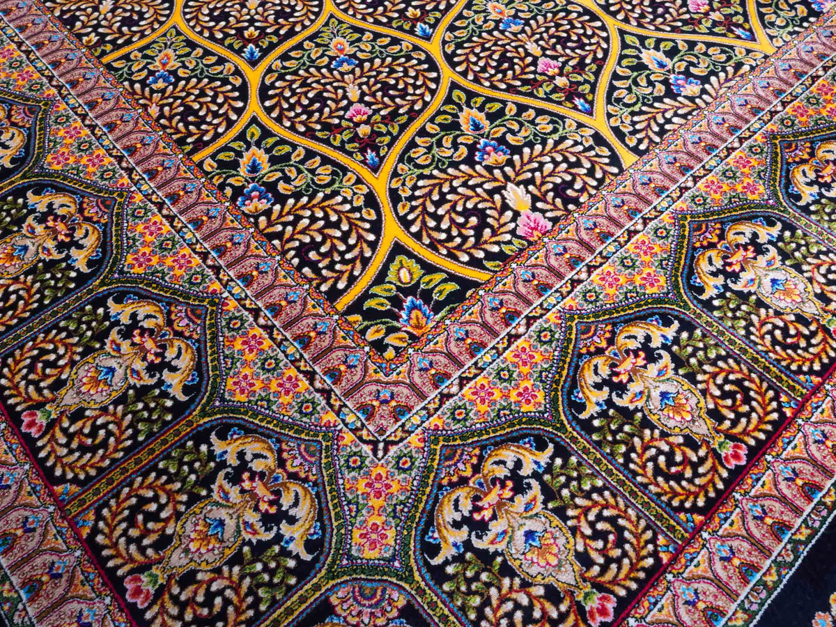 Ghom Maschinenteppich "Manuchehr" 225 x 150 cm, mit Medaillon, aus pflanzlicher Seide (Viskose), Schwarz/Gold. Teppichnummer: V56BG338H. Persian Luxury Collection by Khademi. Made in Iran / Persia – Vertrieb durch JUPITER Intl.