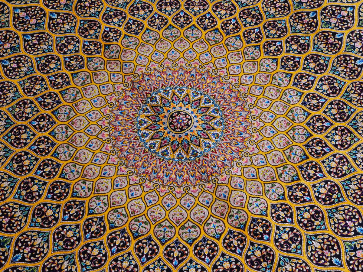 Ghom Maschinenteppich "Manuchehr" 225 x 150 cm, mit Medaillon, aus pflanzlicher Seide (Viskose), Schwarz/Gold. Teppichnummer: V56BG338H. Persian Luxury Collection by Khademi. Made in Iran / Persia – Vertrieb durch JUPITER Intl.