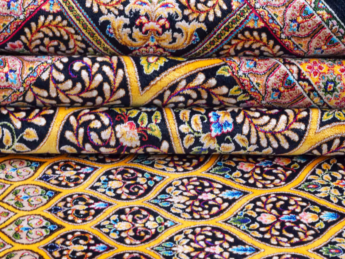 Ghom Maschinenteppich "Manuchehr" 225 x 150 cm, mit Medaillon, aus pflanzlicher Seide (Viskose), Schwarz/Gold. Teppichnummer: V56BG338H. Persian Luxury Collection by Khademi. Made in Iran / Persia – Vertrieb durch JUPITER Intl.