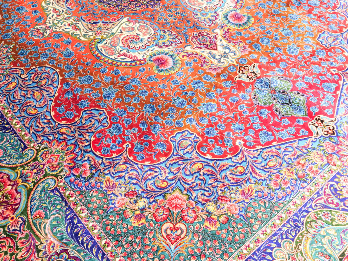 Ghom Maschinenteppich "Nariman" 225 x 150 cm, mit Medaillon, aus pflanzlicher Seide (Viskose), Rot/Mehrfarbig. Teppichnummer: V64RD338H. Persian Luxury Collection by Khademi. Made in Iran / Persia – Vertrieb durch JUPITER Intl.