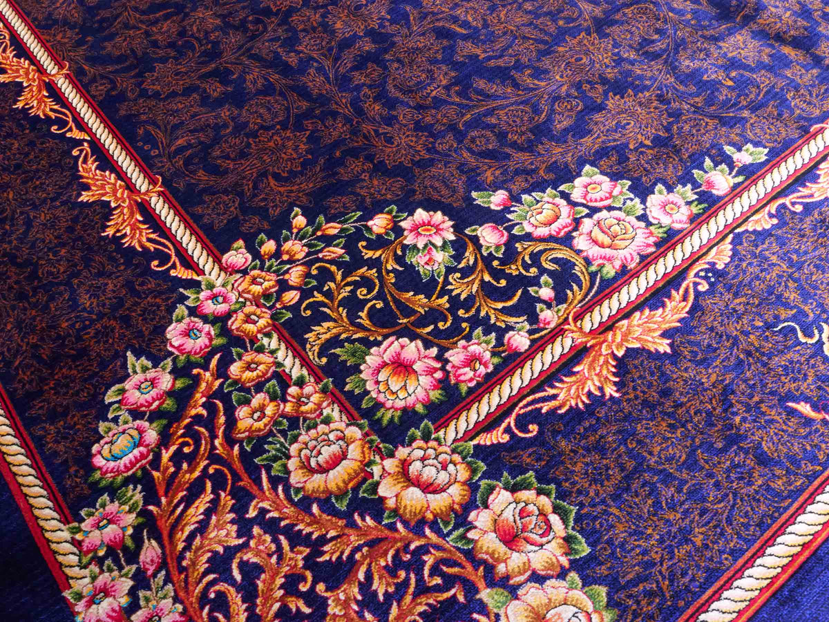 Ghom Maschinenteppich "Piruz" 225 x 150 cm, mit Medaillon, aus pflanzlicher Seide (Viskose), Marineblau/Orange/Gold. Teppichnummer: V69NY338H. Persian Luxury Collection by Khademi. Made in Iran / Persia – Vertrieb durch JUPITER Intl.