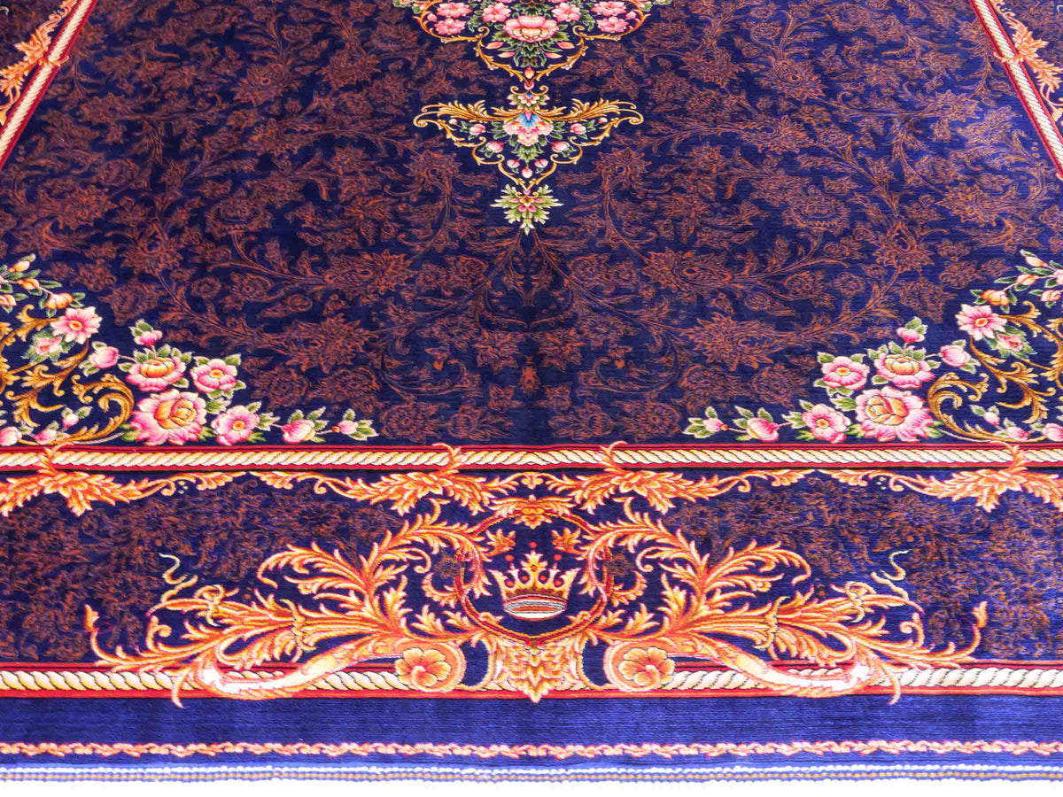 Ghom Maschinenteppich "Piruz" 225 x 150 cm, mit Medaillon, aus pflanzlicher Seide (Viskose), Marineblau/Orange/Gold. Teppichnummer: V69NY338H. Persian Luxury Collection by Khademi. Made in Iran / Persia – Vertrieb durch JUPITER Intl.