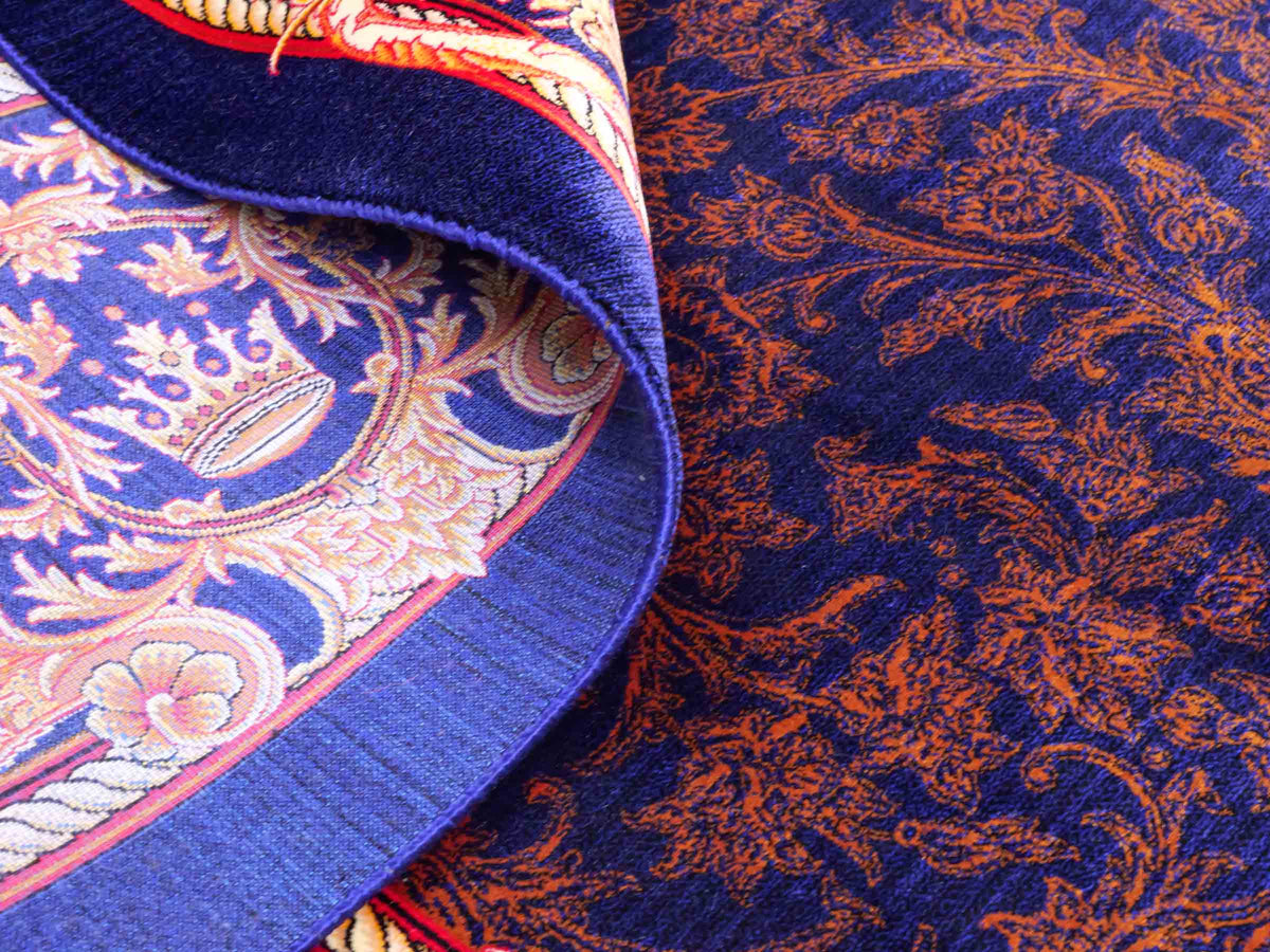 Ghom Maschinenteppich "Piruz" 225 x 150 cm, mit Medaillon, aus pflanzlicher Seide (Viskose), Marineblau/Orange/Gold. Teppichnummer: V69NY338H. Persian Luxury Collection by Khademi. Made in Iran / Persia – Vertrieb durch JUPITER Intl.