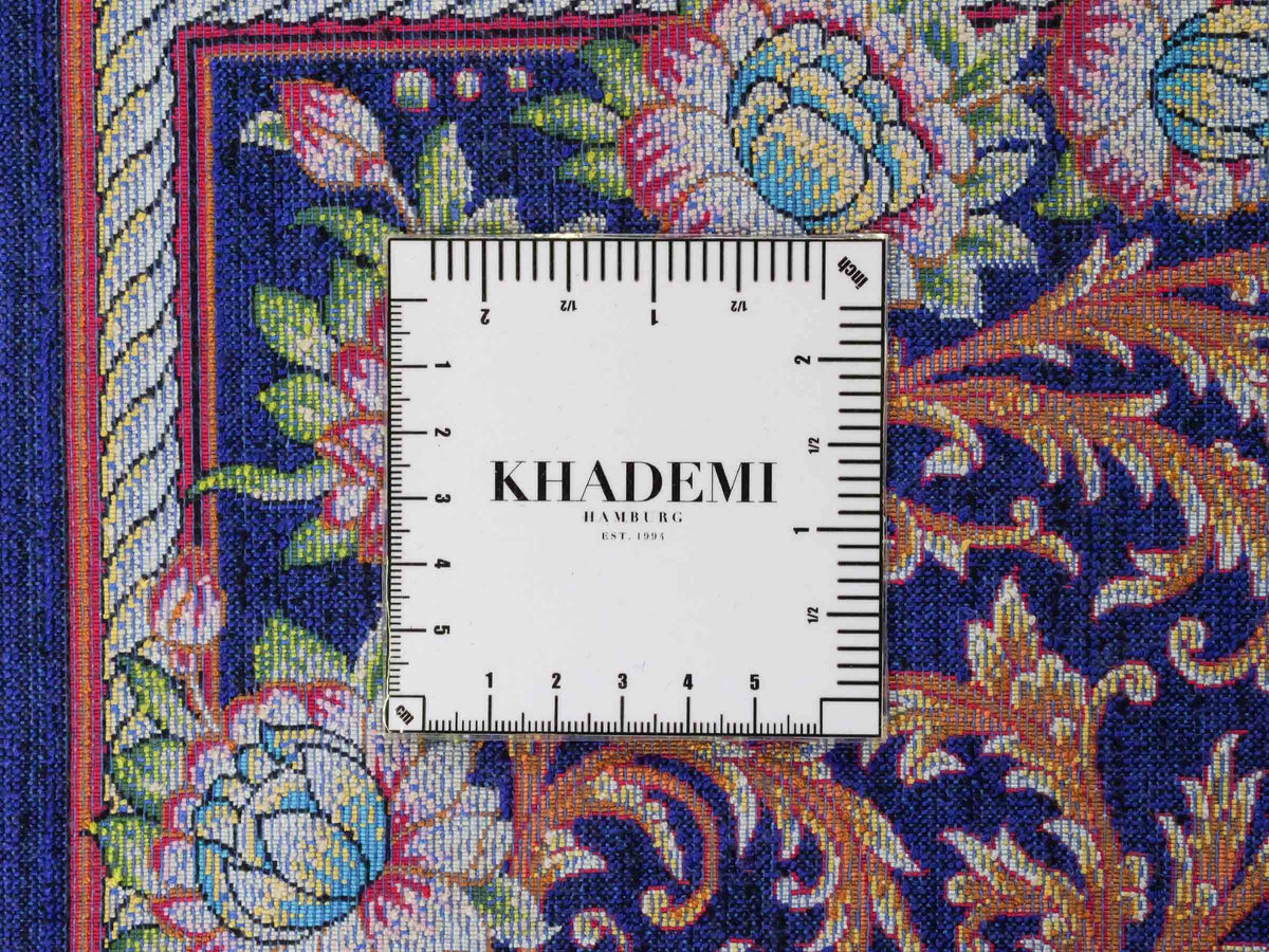 Ghom Maschinenteppich "Piruz" 225 x 150 cm, mit Medaillon, aus pflanzlicher Seide (Viskose), Marineblau/Orange/Gold. Teppichnummer: V69NY338H. Persian Luxury Collection by Khademi. Made in Iran / Persia – Vertrieb durch JUPITER Intl.
