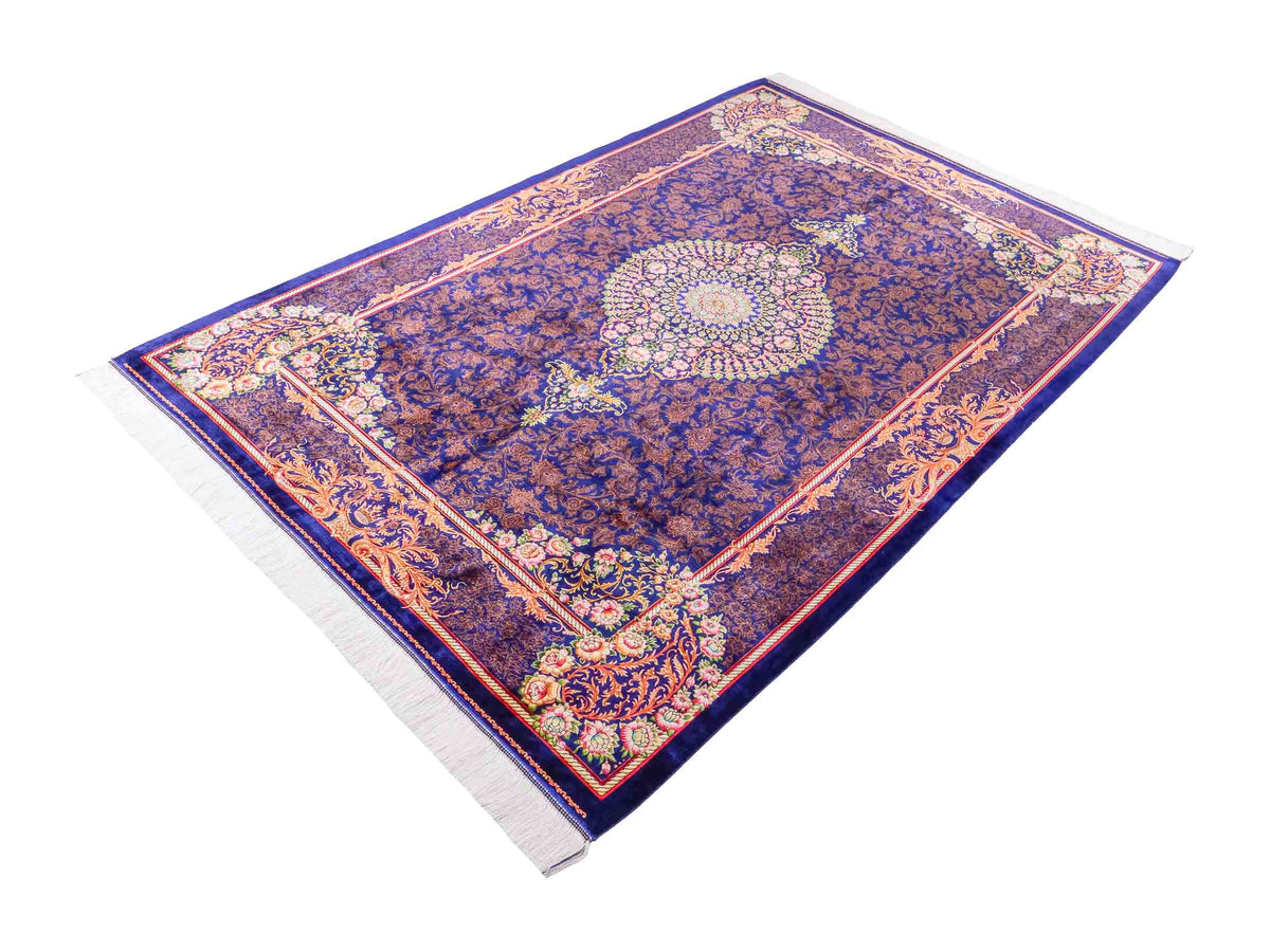 Ghom Maschinenteppich "Piruz" 225 x 150 cm, mit Medaillon, aus pflanzlicher Seide (Viskose), Marineblau/Orange/Gold. Teppichnummer: V69NY338H. Persian Luxury Collection by Khademi. Made in Iran / Persia – Vertrieb durch JUPITER Intl.