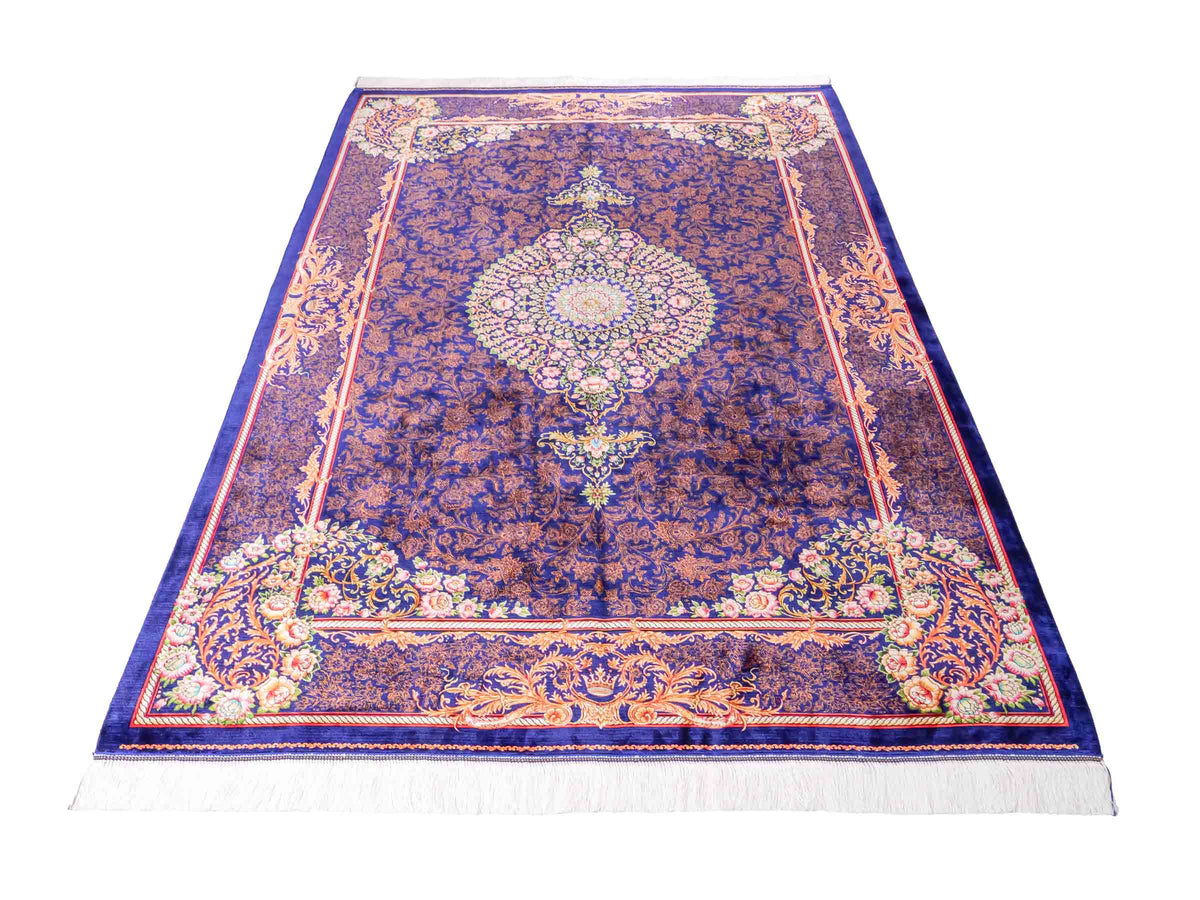 Ghom Maschinenteppich "Piruz" 225 x 150 cm, mit Medaillon, aus pflanzlicher Seide (Viskose), Marineblau/Orange/Gold. Teppichnummer: V69NY338H. Persian Luxury Collection by Khademi. Made in Iran / Persia – Vertrieb durch JUPITER Intl.