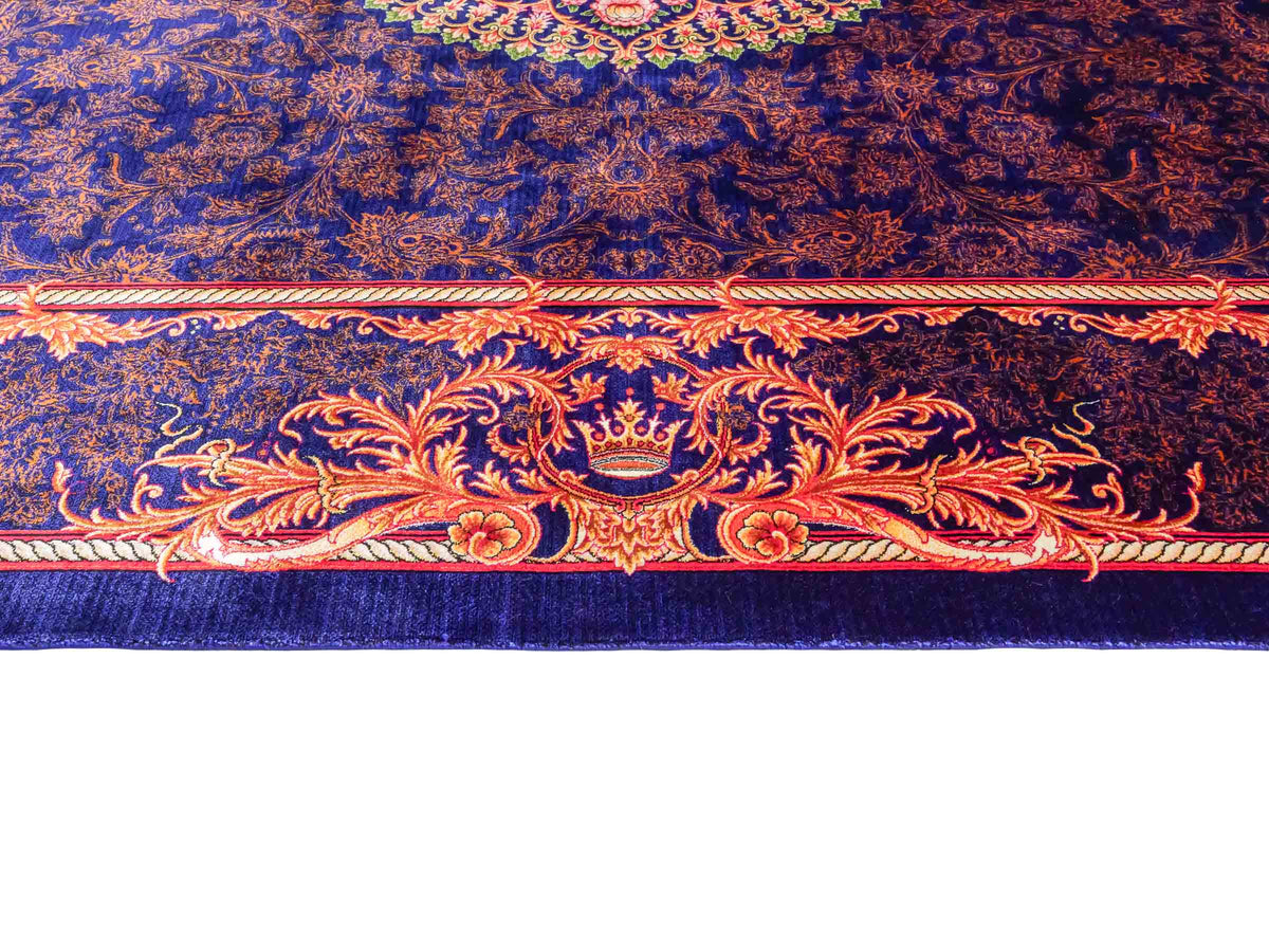 Ghom Maschinenteppich "Piruz" 225 x 150 cm, mit Medaillon, aus pflanzlicher Seide (Viskose), Marineblau/Orange/Gold. Teppichnummer: V69NY338H. Persian Luxury Collection by Khademi. Made in Iran / Persia – Vertrieb durch JUPITER Intl.