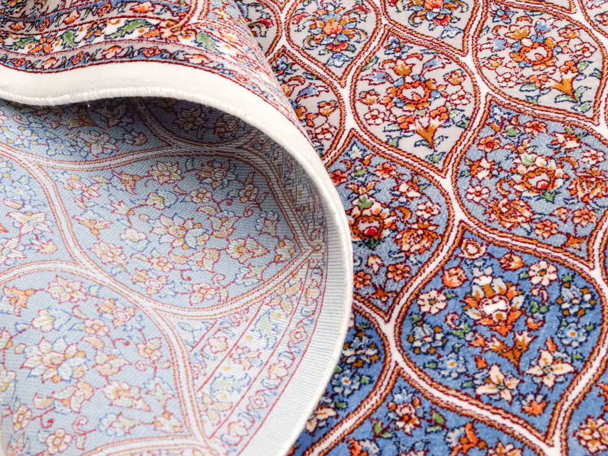 Ghom Maschinenteppich "Rudabeh" 180 x 120 cm, mit Medaillon, aus pflanzlicher Seide (Viskose), Cremeweiß-Blau. Teppichnummer: V72CR216H. Persian Luxury Collection by Khademi. Made in Iran / Persia – Vertrieb durch JUPITER Intl.