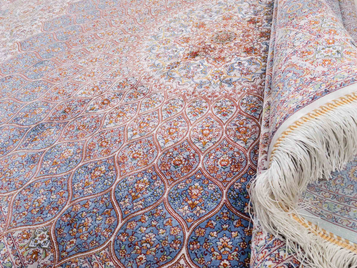 Ghom Maschinenteppich "Rudabeh" 180 x 120 cm, mit Medaillon, aus pflanzlicher Seide (Viskose), Cremeweiß-Blau. Teppichnummer: V72CR216H. Persian Luxury Collection by Khademi. Made in Iran / Persia – Vertrieb durch JUPITER Intl.