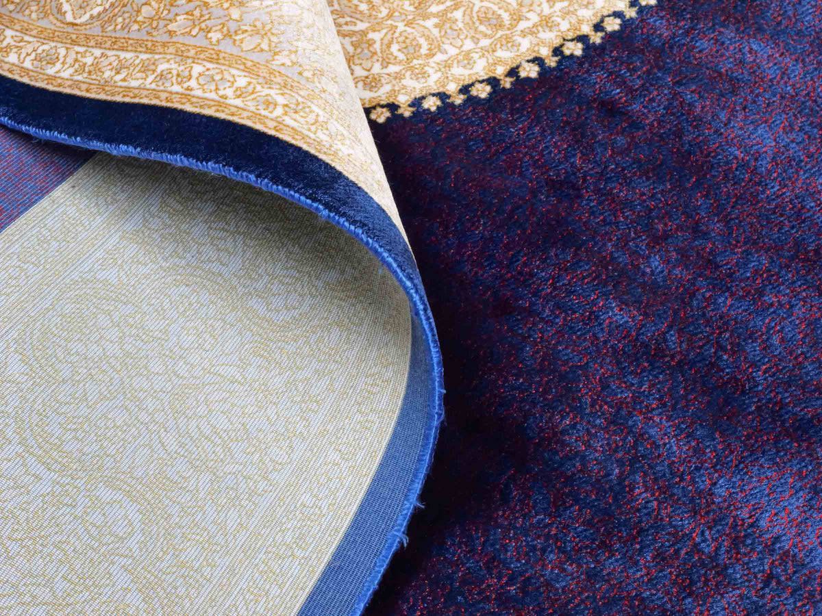 Ghom Maschinenteppich "Soroush" 180 x 120 cm, mit Medaillon, aus pflanzlicher Seide (Viskose), Marineblau-Cremeweiß-Lila. Teppichnummer: V81NY216H. Persian Luxury Collection by Khademi. Made in Iran / Persia – Vertrieb durch JUPITER Intl.