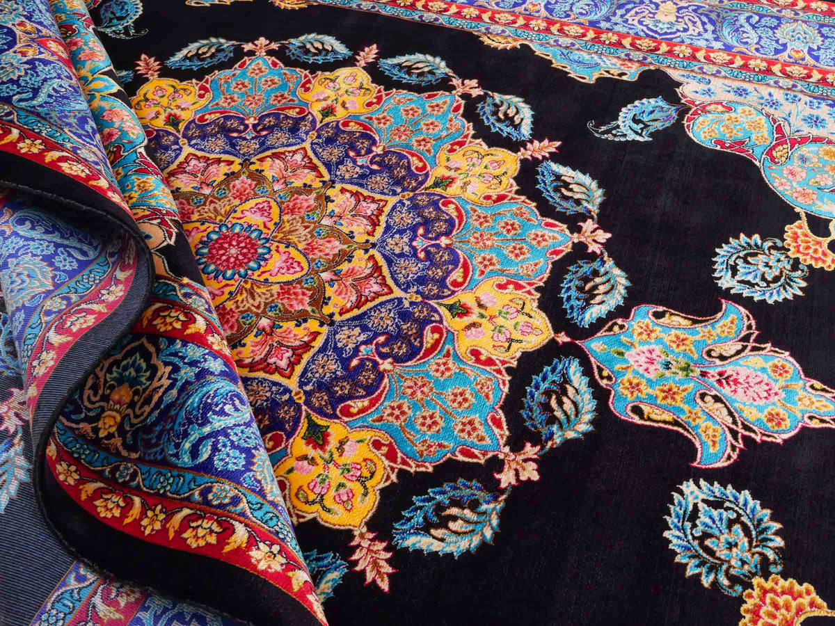 Ghom Maschinenteppich "Tahmina" 150 x 100 cm, mit Spiegel-Medaillon, aus pflanzlicher Seide (Viskose), Schwarz-Blau. Teppichnummer: V87BK150H. Persian Luxury Collection by Khademi. Made in Iran / Persia – Vertrieb durch JUPITER Intl.